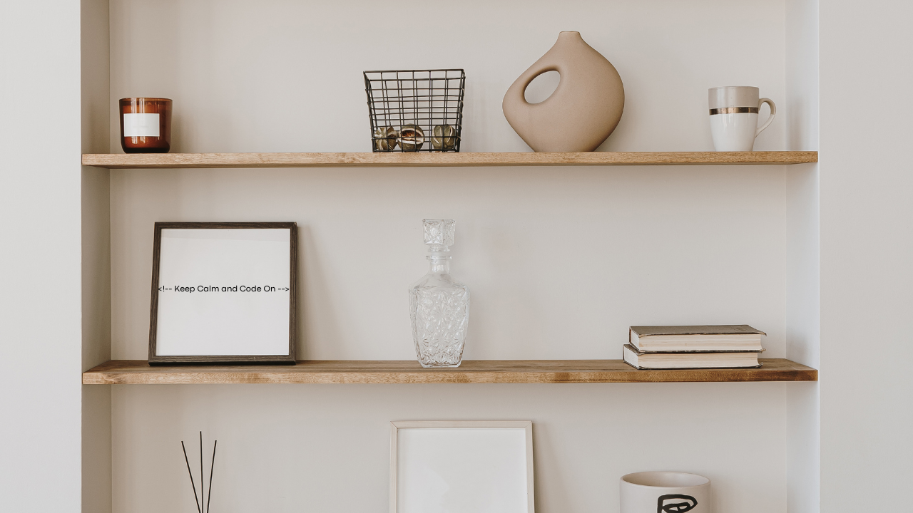 Decorative display on three wooden shelves with vases, books, and framed artwork.