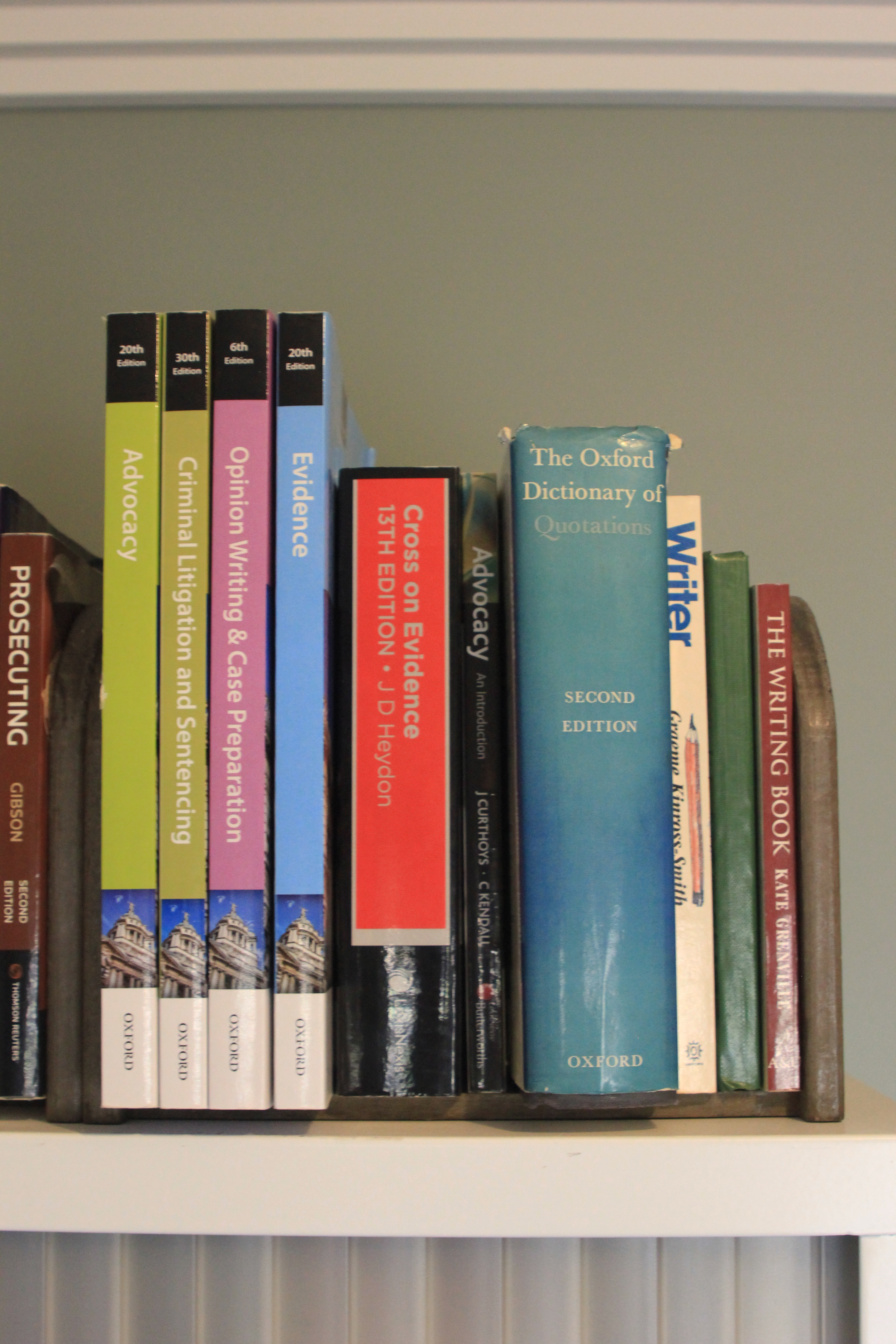 Shelf of books related to law and writing, including titles on advocacy, criminal litigation, evidence, citation, and a second edition of The Oxford Dictionary of Quotations.