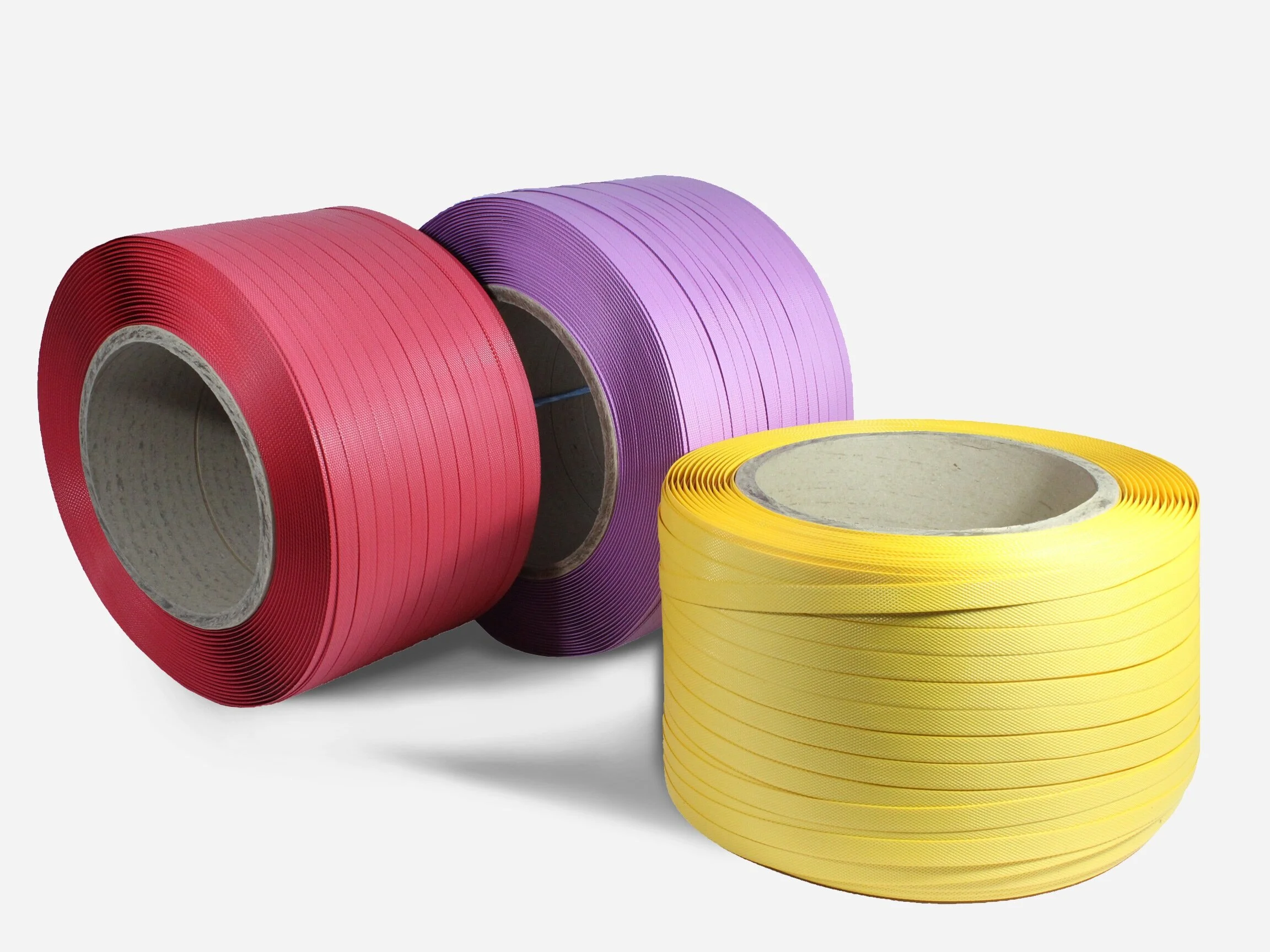 Three large spools of tape in red, purple, and yellow colors placed on a white background.