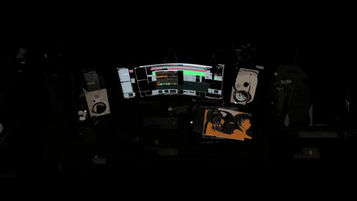 A music production studio with multiple monitors displaying audio editing software, surrounded by studio speakers and audio equipment.