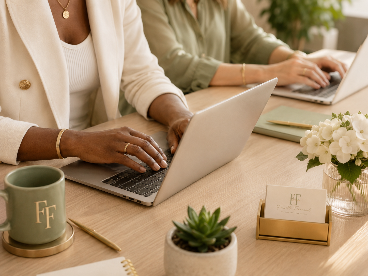 Sabrina M. Fonville reviewing books on a laptop with a client, bookkeeping and payroll services in Falls Church, VA
