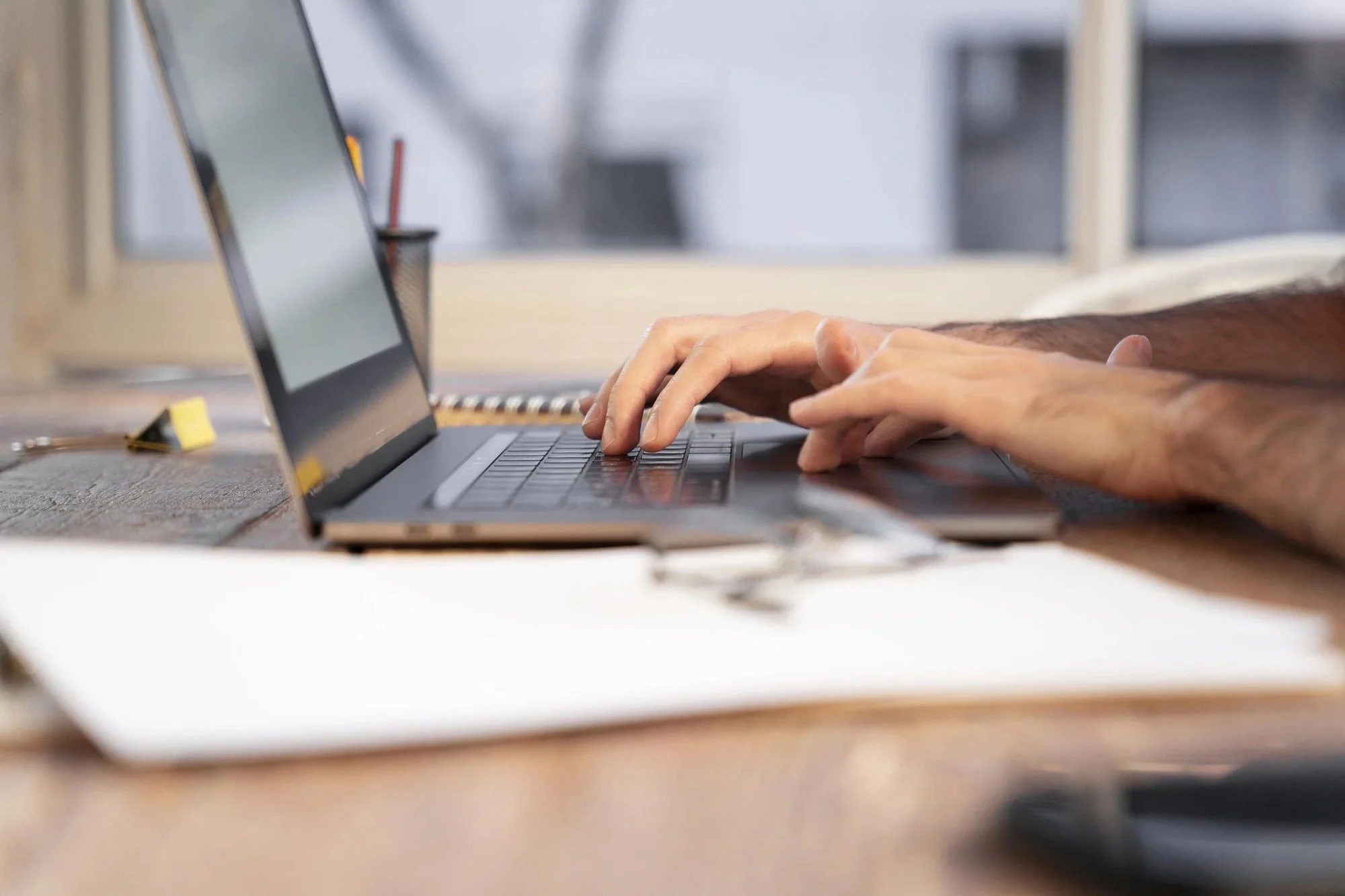 close up of a woman entrepreneur typing on a laptop at her desk, managing bookkeeping, financial reporting, and year-round tax strategy with Fonville Financial & Tax Services.