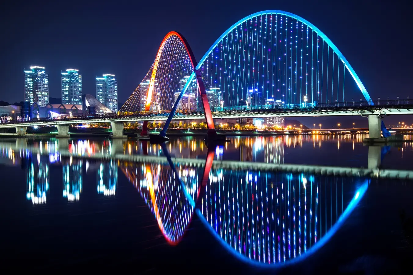 Gwangan Bridge illuminated at night in Busan South Korea representing coastal urban development, tourism districts and real estate investment opportunities