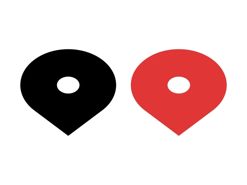 Two location markers, one black and one red, side by side on a white background.