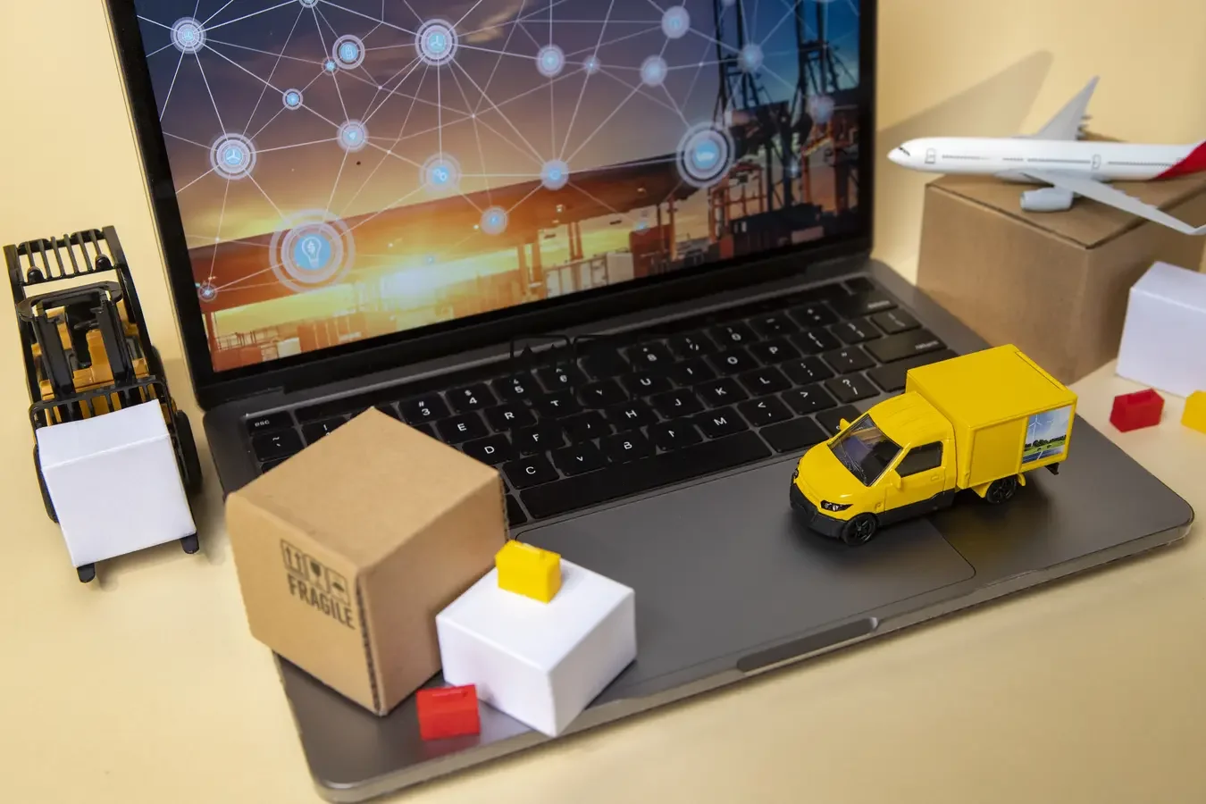 Laptop with packages and delivery vehicles, illustrating logistics and e-commerce operations management