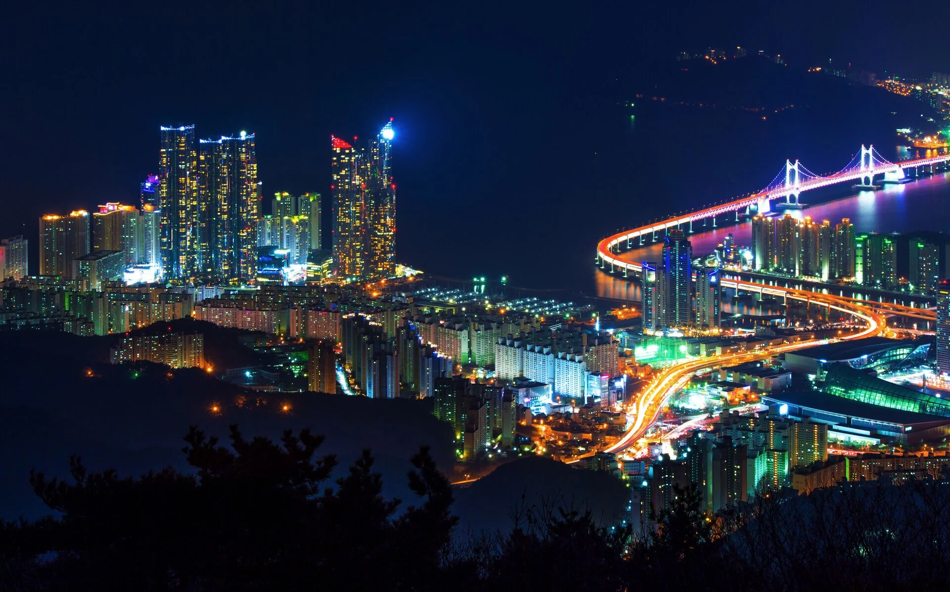 Busan city at night from above with illuminated roads, representing Korean business growth, strategy, profit, and turnaround opportunities.