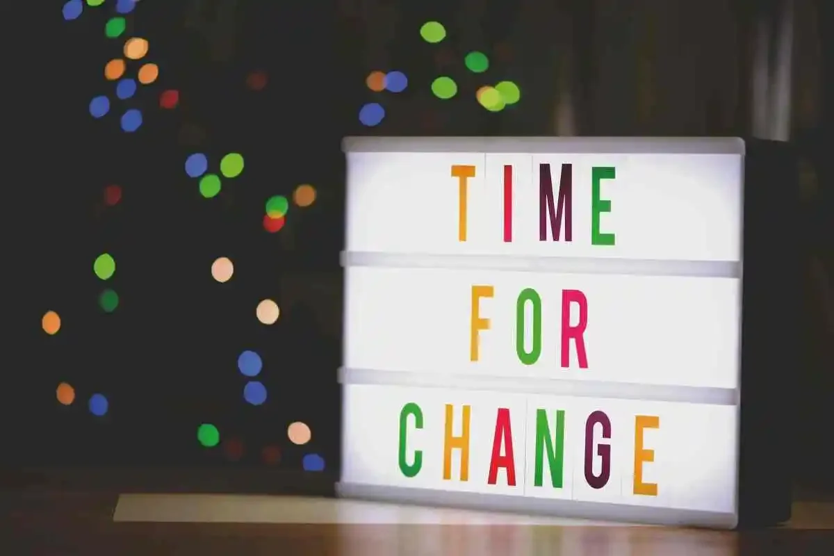 Lightbox with the words 'Time for Change' spelled out in colorful letters, against a dark background with blurred multicolored lights.