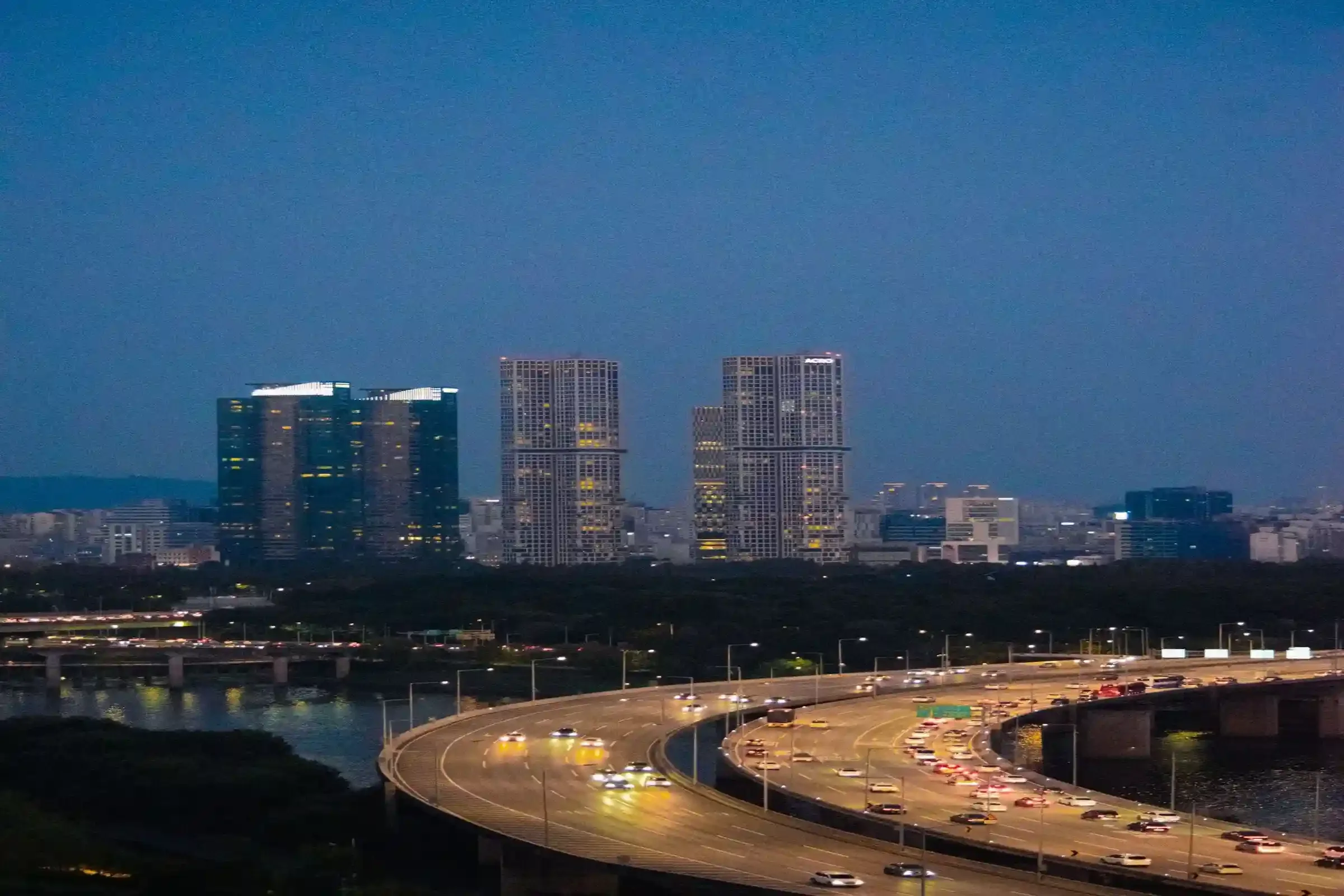 Modern city skyline with glass architecture and golden light, symbolizing business expansion, growth opportunities and strategic decisions across Korea and Asia.
