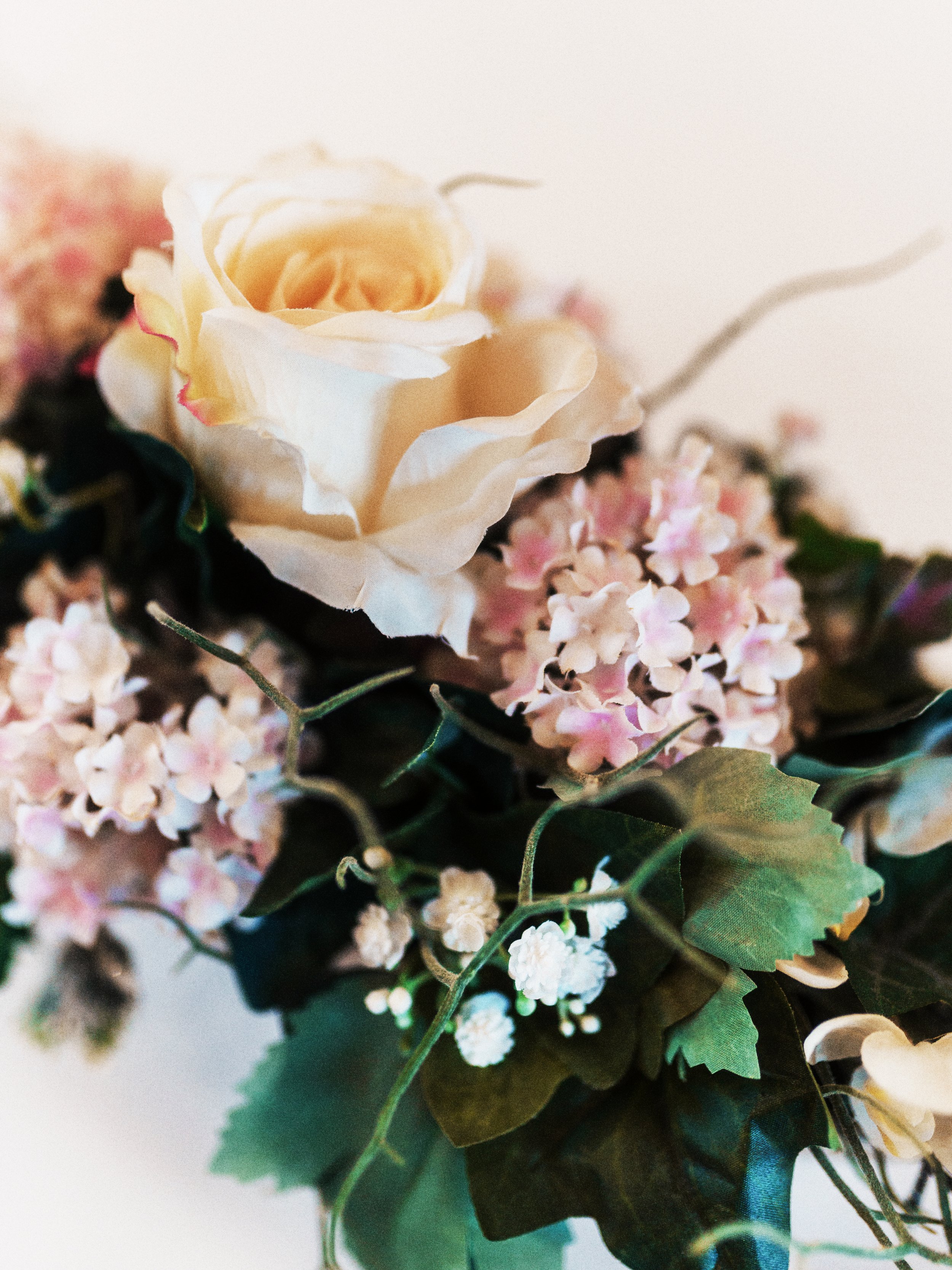 Blumenstrauß mit weißen Rosen und pinken Hortensien, grüne Blätter und dünne Zweige.