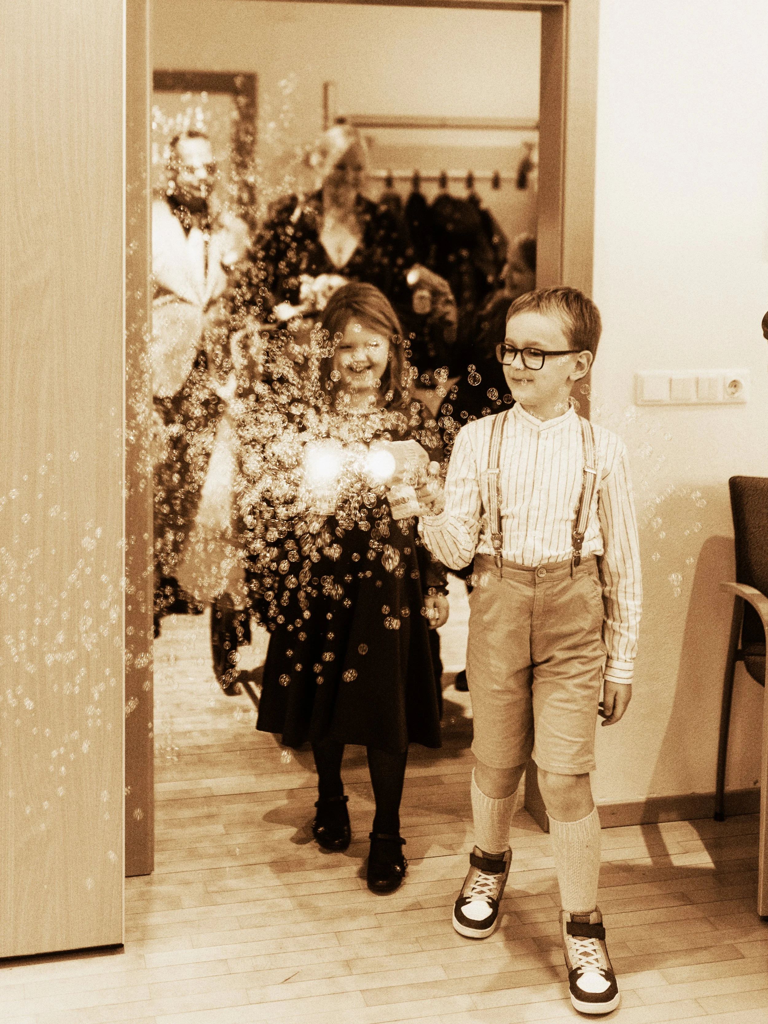 Kinder feiern eine Party, ein Junge und ein Mädchen, bei dem Mädchen sprüht Konfetti.