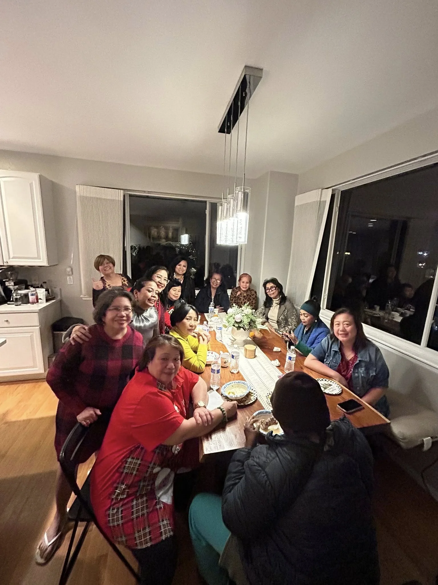 People gathered around a dining table for a gathering or celebration in a modern home.