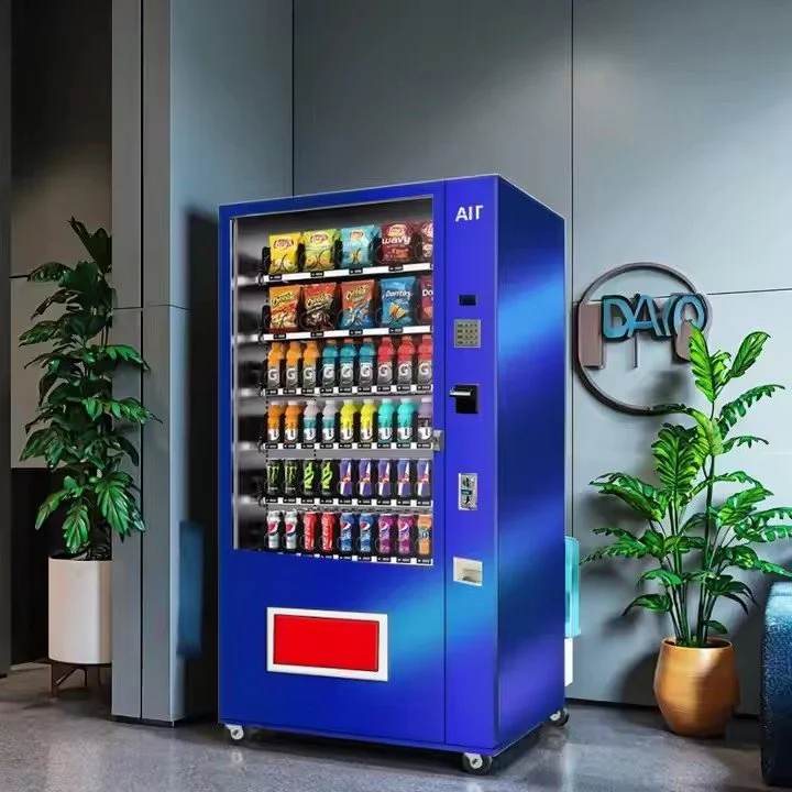 Blue snack and beverage vending machine with snacks and drinks, positioned next to gray wall and potted plants in modern indoor setting.