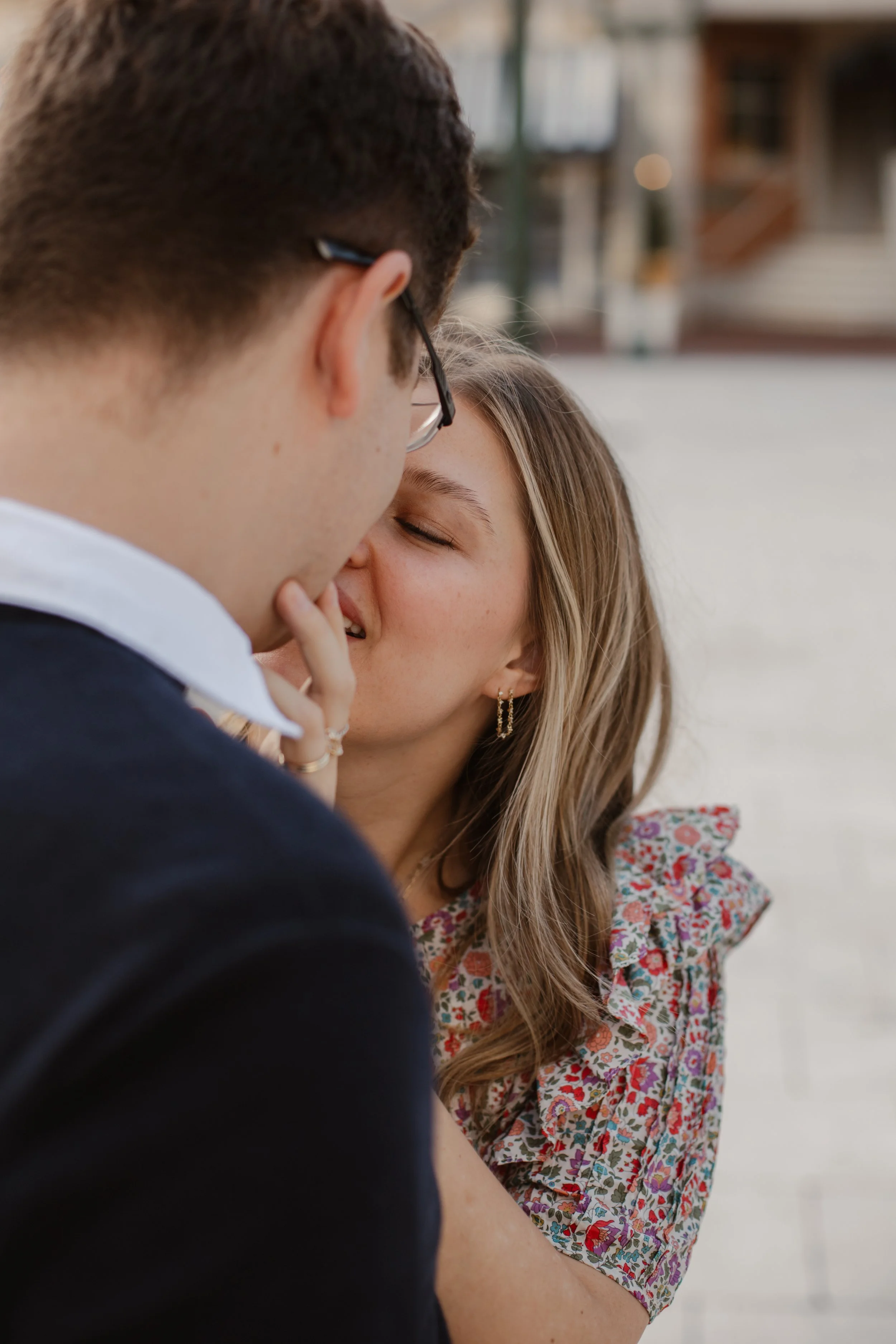 A couple sharing an intimate moment, about to kiss, with the woman's eyes closed and hand gently touching the man's face.