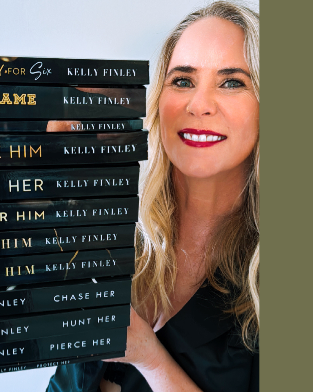 A woman with blonde wavy hair, red lipstick, and a nose ring holding a tall stack of books by Kelly Finley.