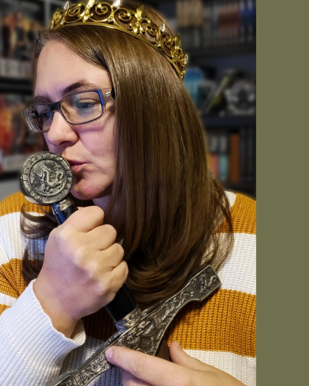 A woman with brown hair, glasses, and a gold crown, holding a sword and a large coin with a figure on it, inside a room with bookshelves.