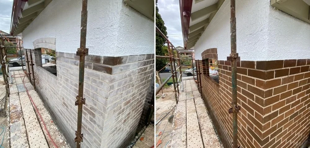Side view of a building under construction, showing a brick wall being freshly painted red, with scaffolding and open windows, and a sidewalk next to the building.
