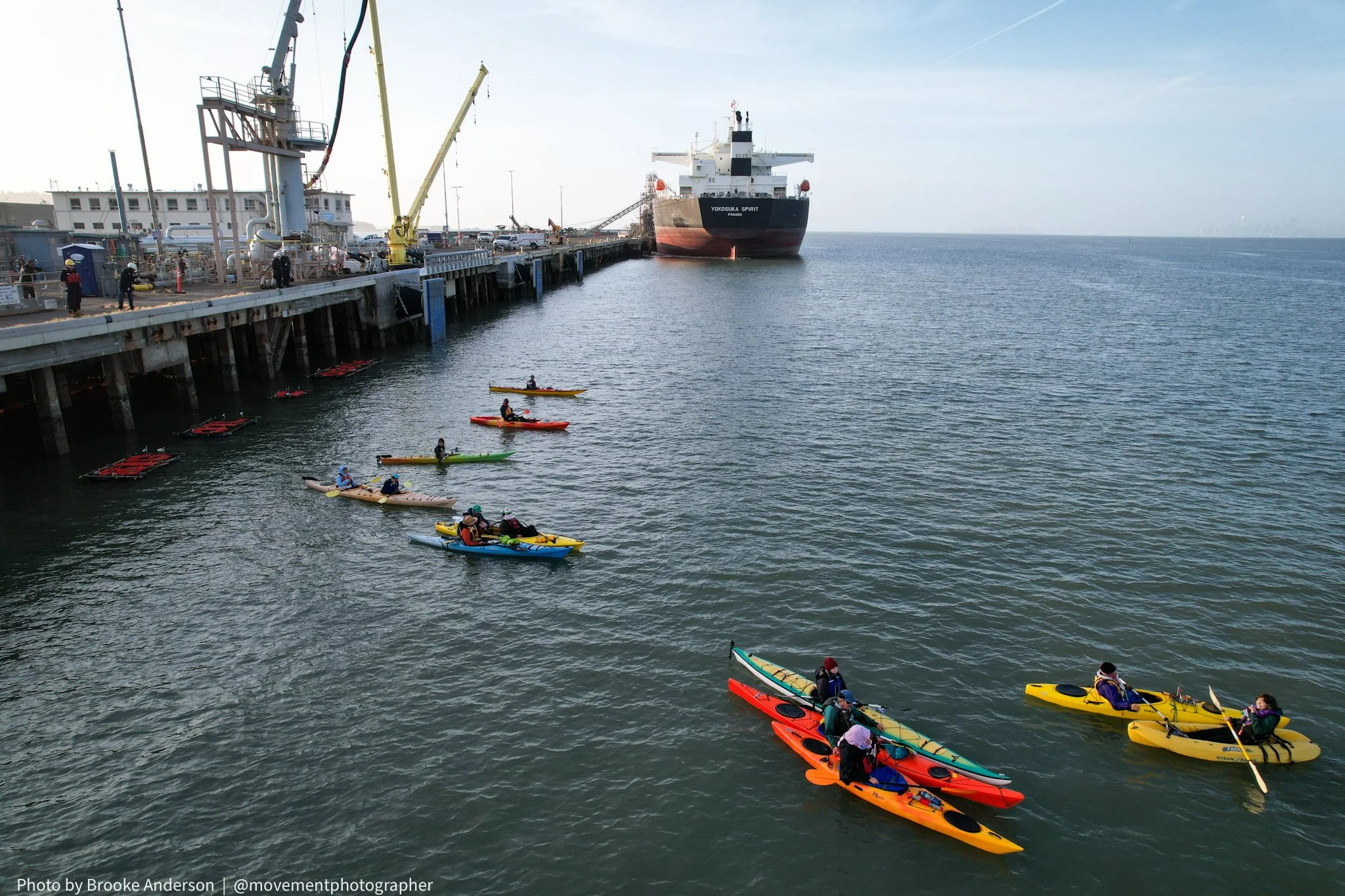Kayak activists at the Richmond long wharf in front of a tanker ship
