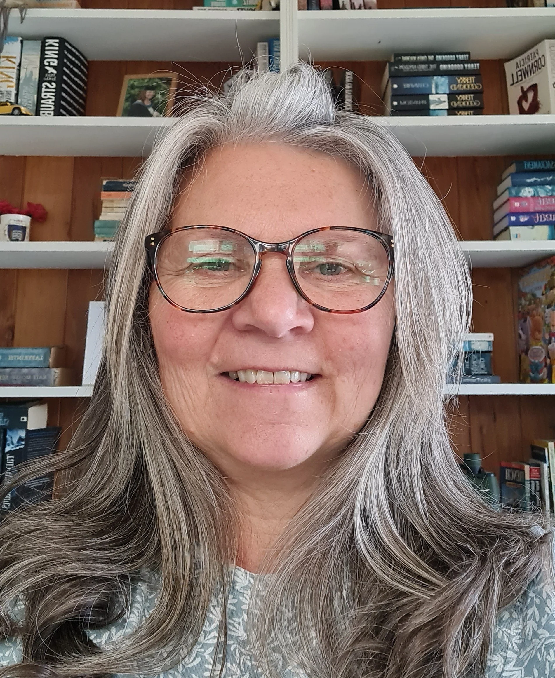 Vikki Ambrose standing in front of a book shelf