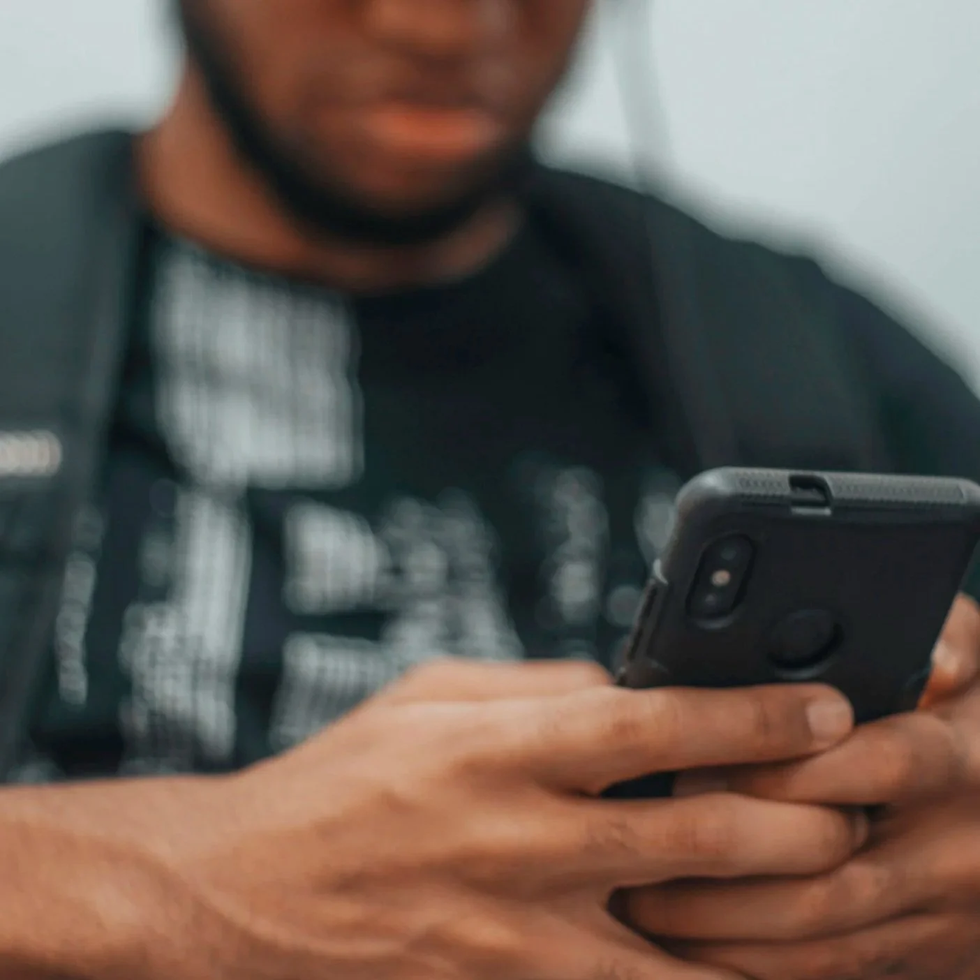 Nahaufnahme eines Mannes, der ein Smartphone hält und benutzt.