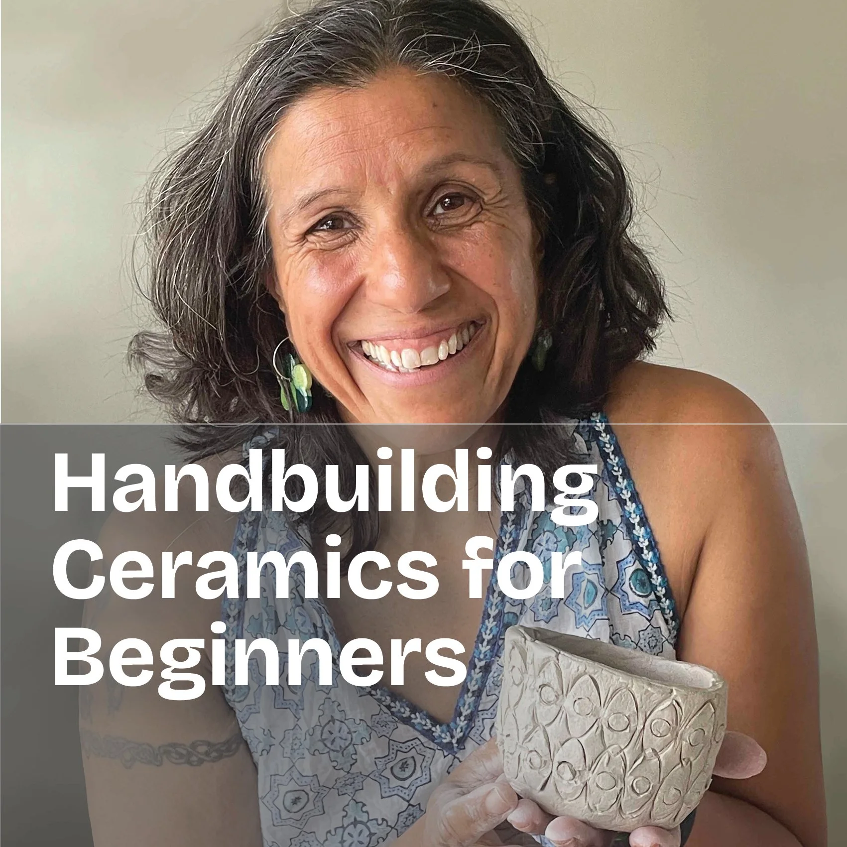 A woman with shoulder-length dark hair smiling, holding a ceramic bowl with patterned carvings.