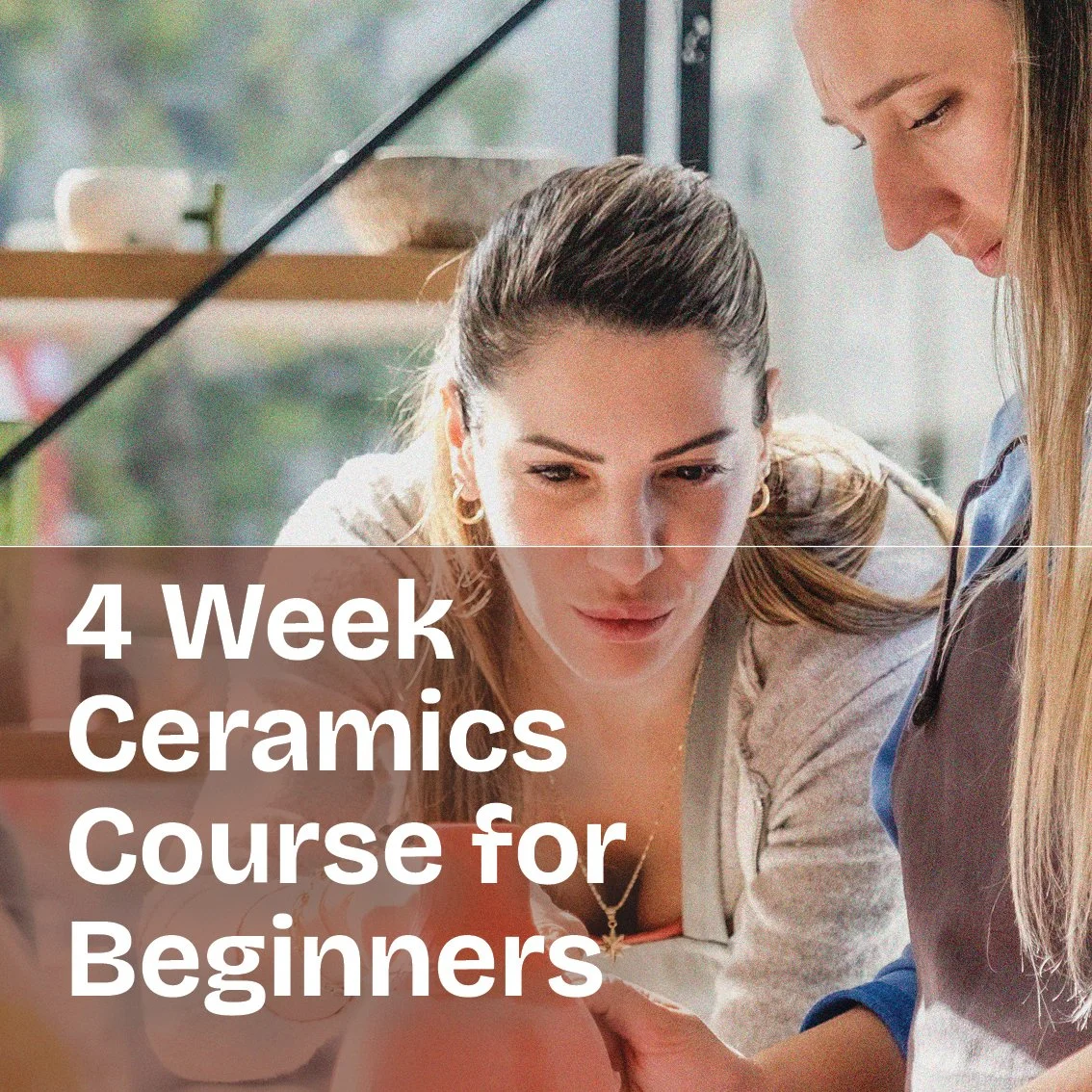 Two women working on a ceramics project together at a desk.