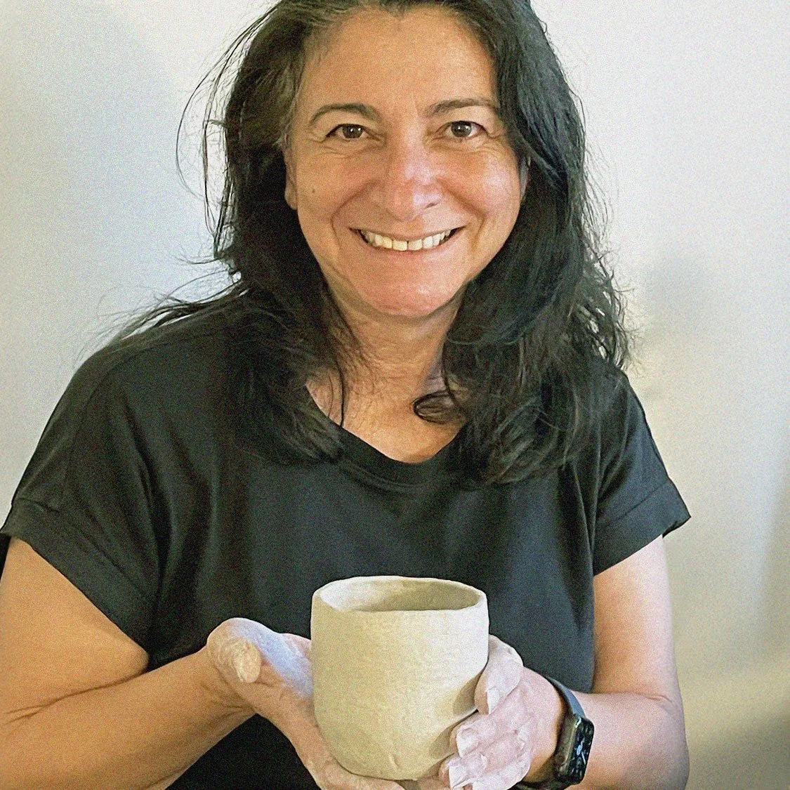 smiling ceramics student with cup at open studio