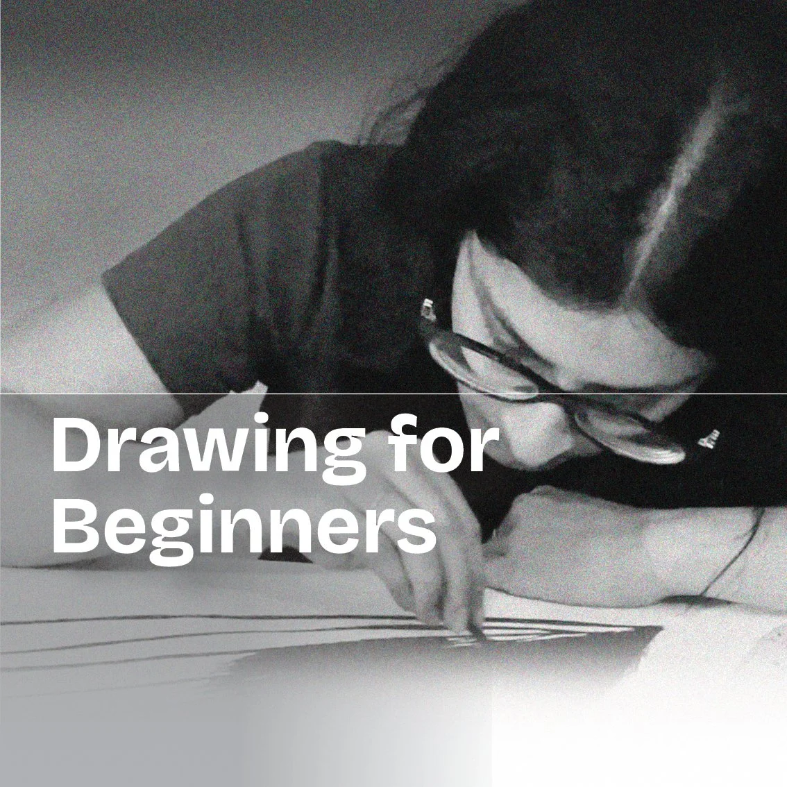 A young girl with glasses drawing on paper with a pencil, focused on her artwork.