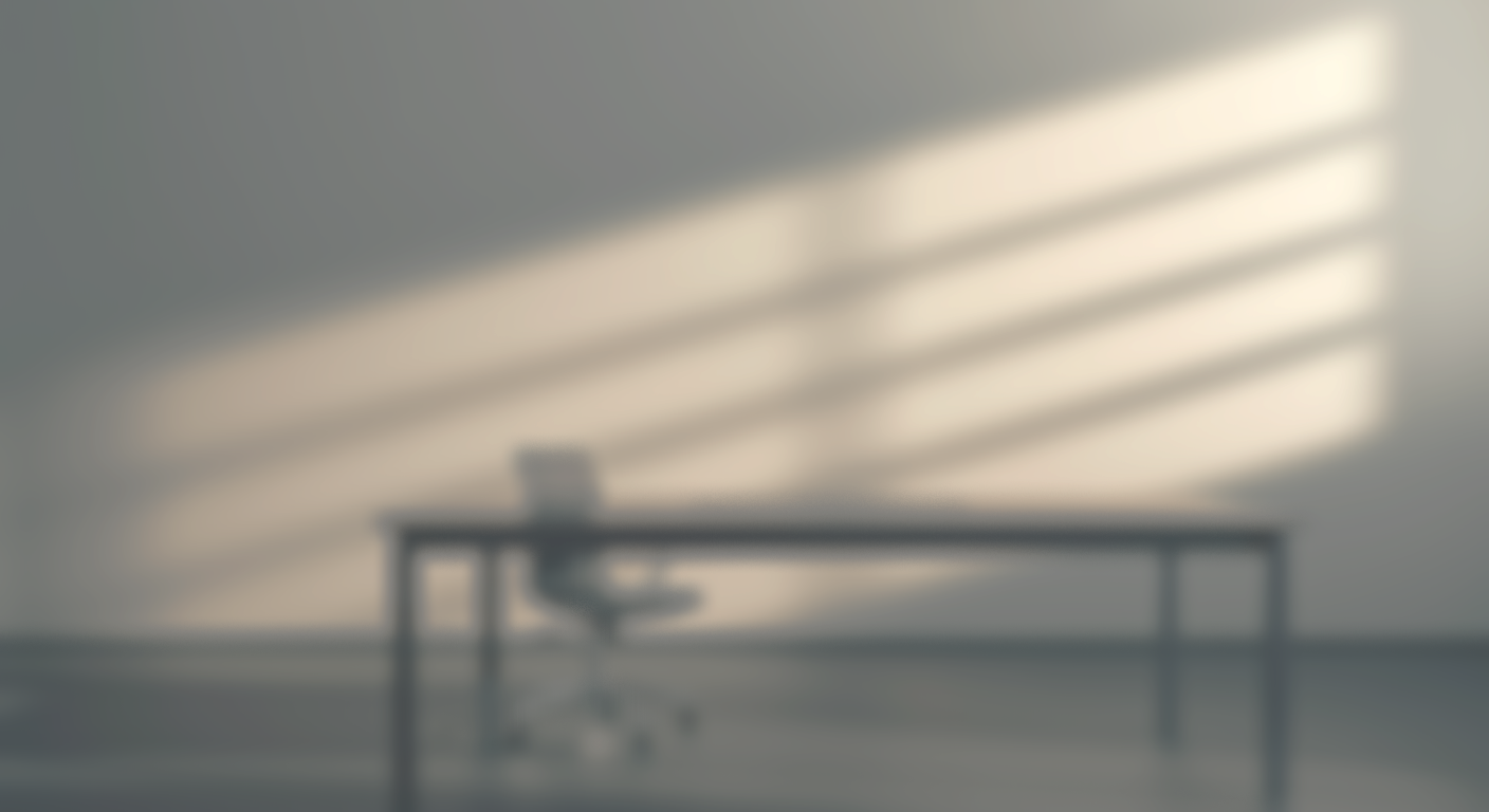 Blurred image of a desk and chair with sunlight casting diagonal shadow stripes on the wall.