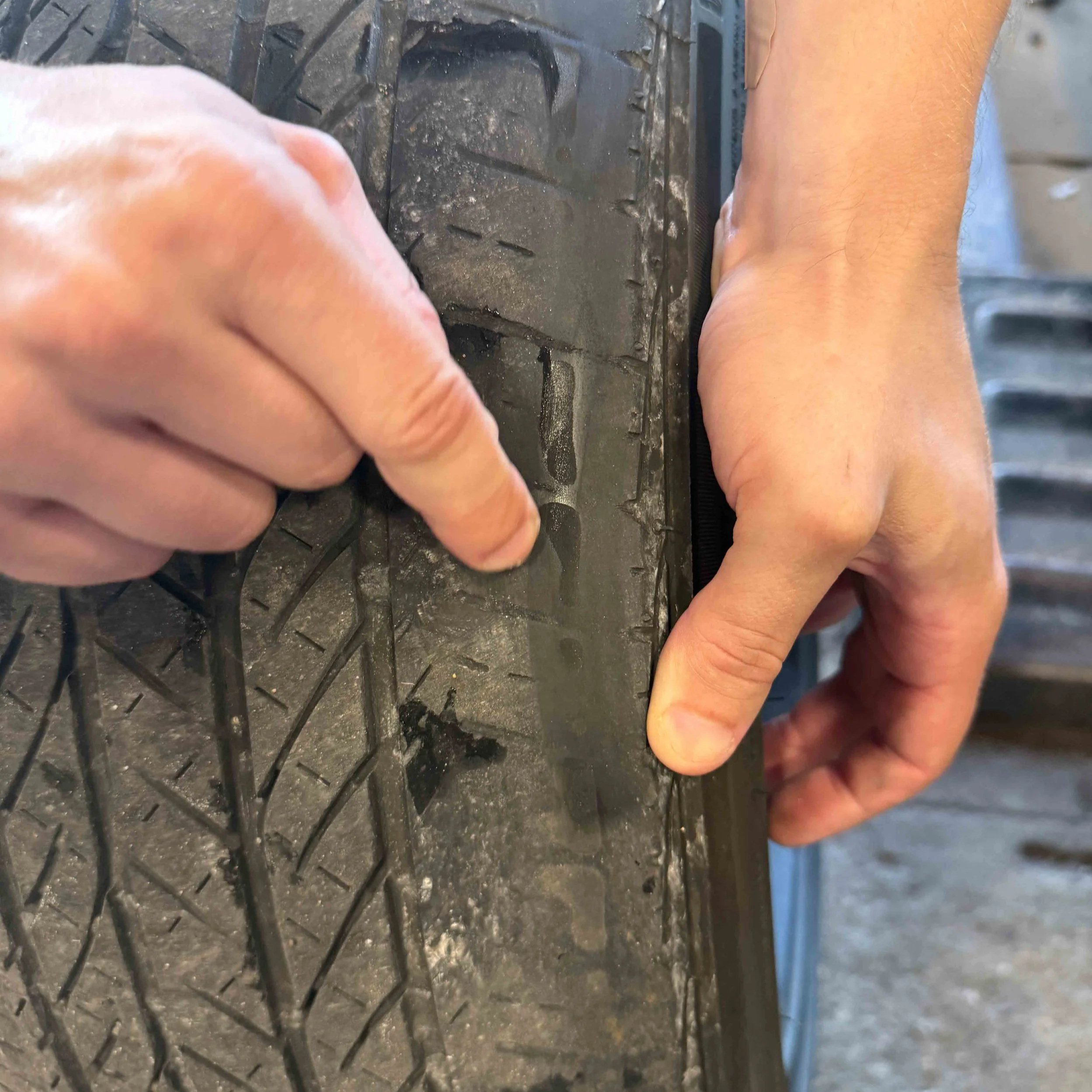 Close-up of worn rental-car tire showing severe inner tread damage.