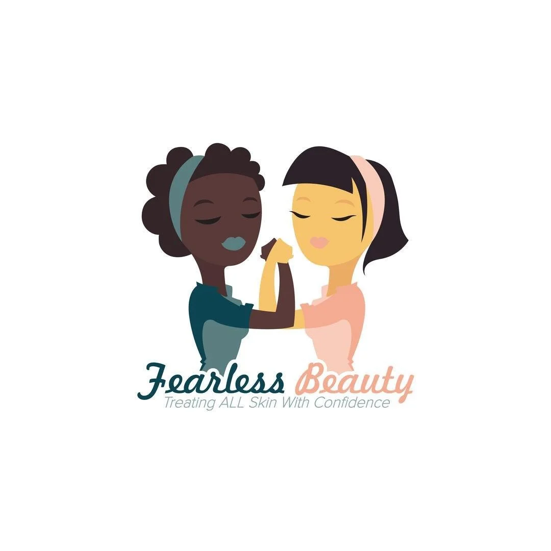 Illustration of two women with closed eyes, one with dark skin and curly hair and the other with light skin and straight black hair, arm wrestling. The image features the text 'Fearless Beauty' and the slogan 'Treating ALL Skin With Confidence'.