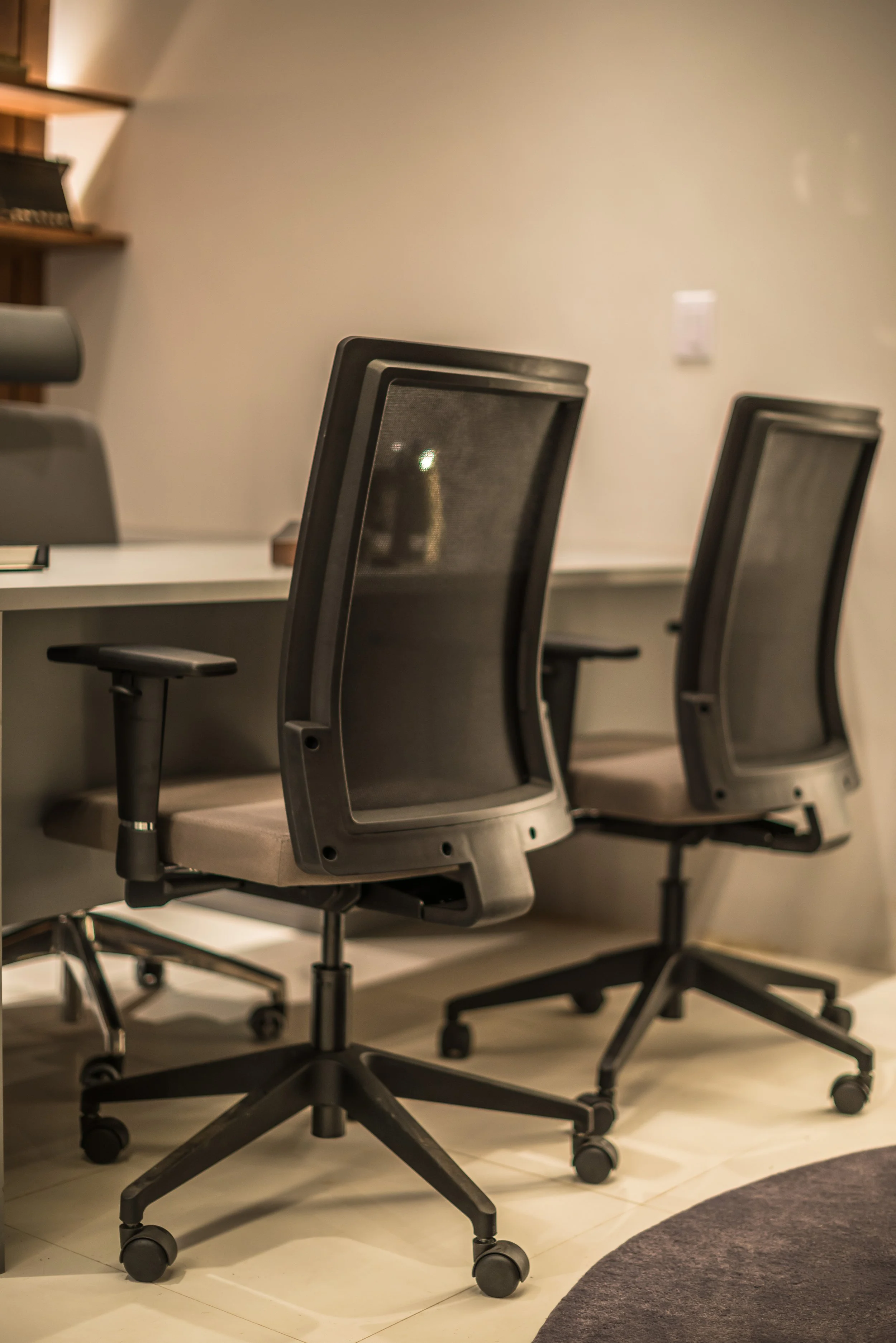 Empty office chairs in front of a desk in an office