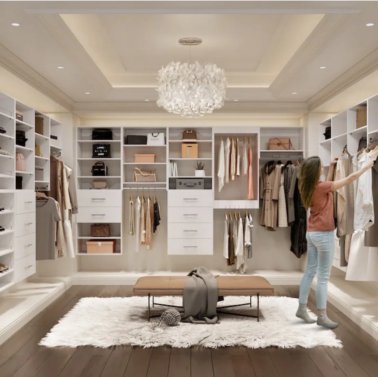A woman organizes clothes in a spacious walk-in closet with white shelving units, hanging clothes, and accessories. A bench and a fluffy rug are in the center.