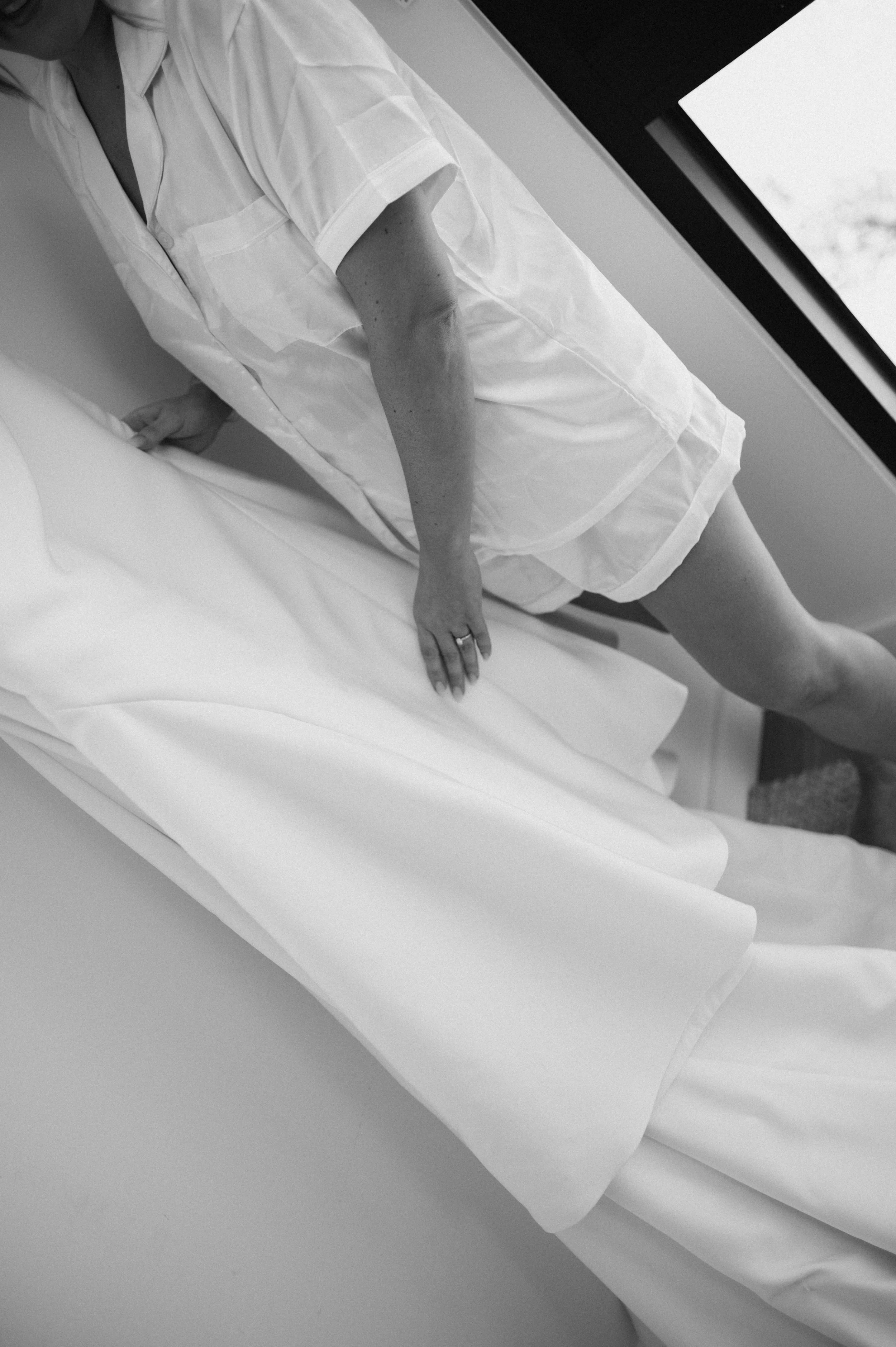 A person in hospital gown lying on a bed in a hospital room.