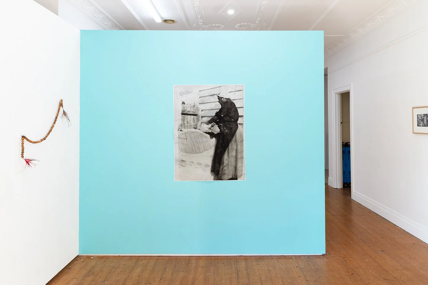 A black and white photograph on a bright blue gallery wall