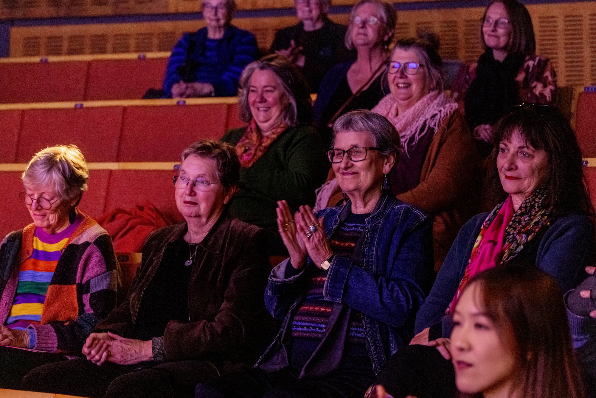 Audience members smiling and applauding