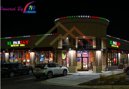 Exterior view of a restaurant called 'El Parian Mexican Grill' with parking spaces in front and cars parked, illuminated signs, and decorative lighting on the building at night.