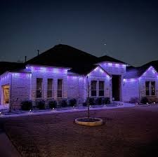 A building decorated with purple holiday lights at night.