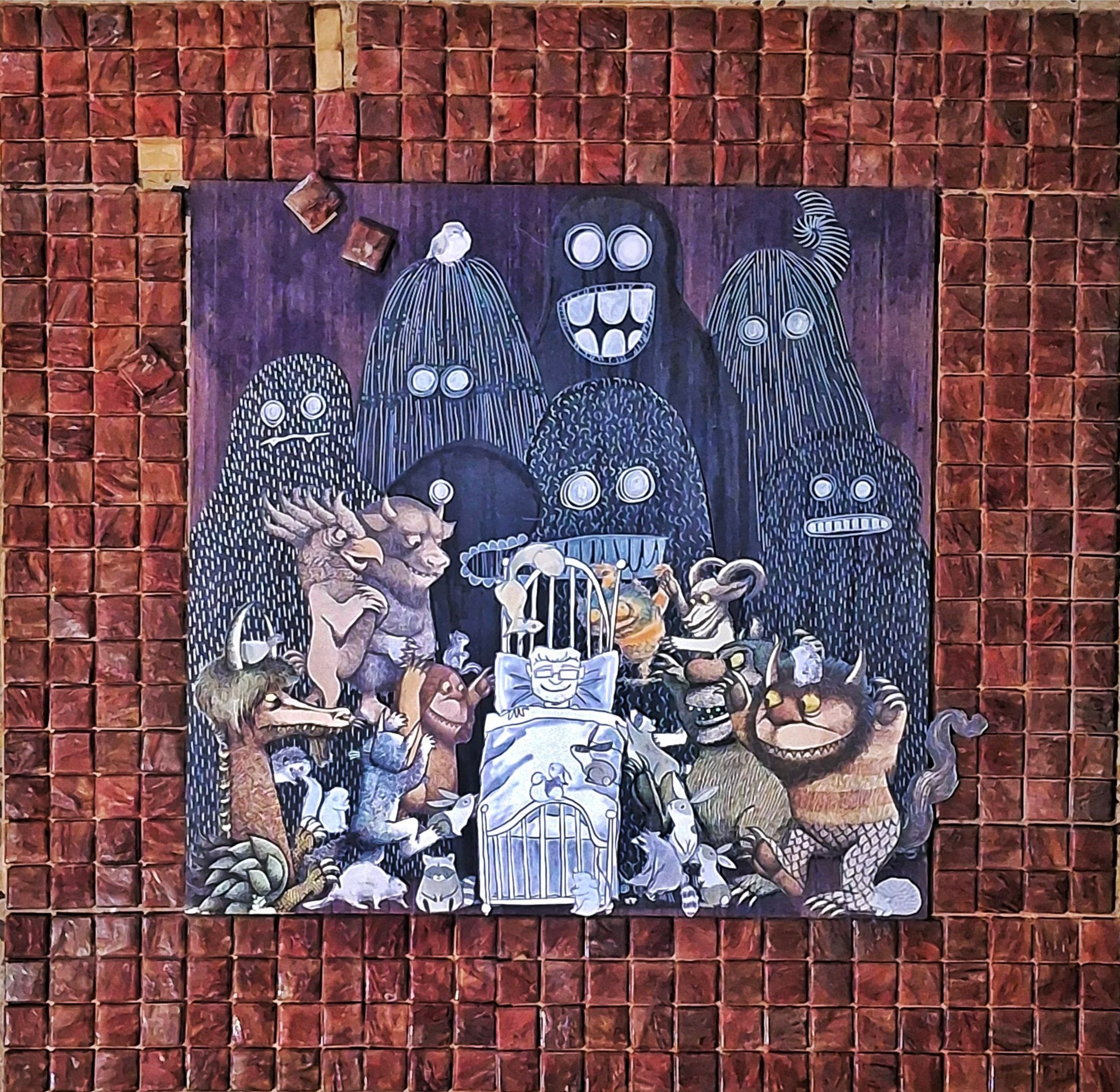 Colorful painting of various cartoonish monsters surrounding a sleeping person, with a red tiled wall background.