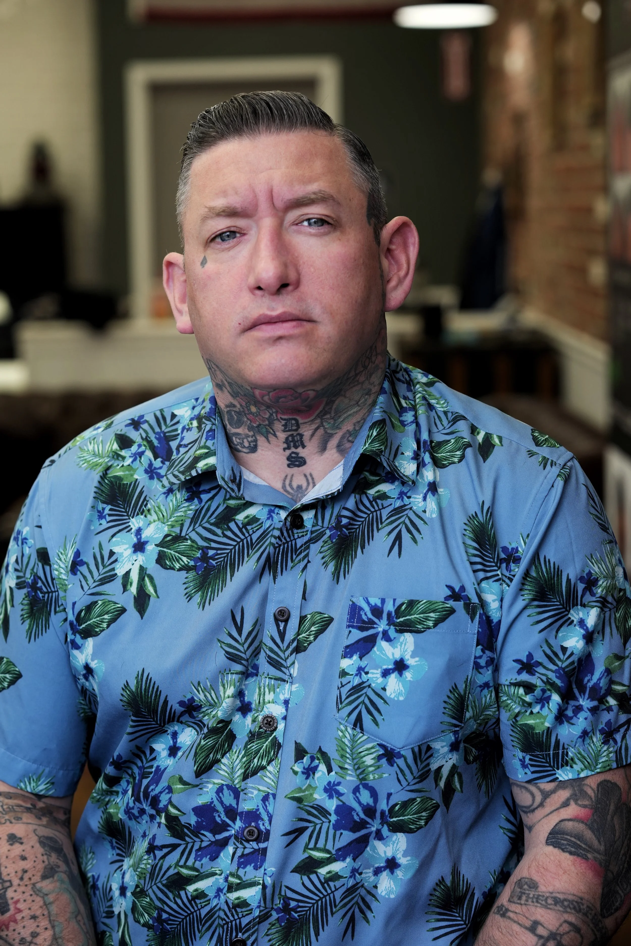 barber with Hawaiian shirt and tattoos