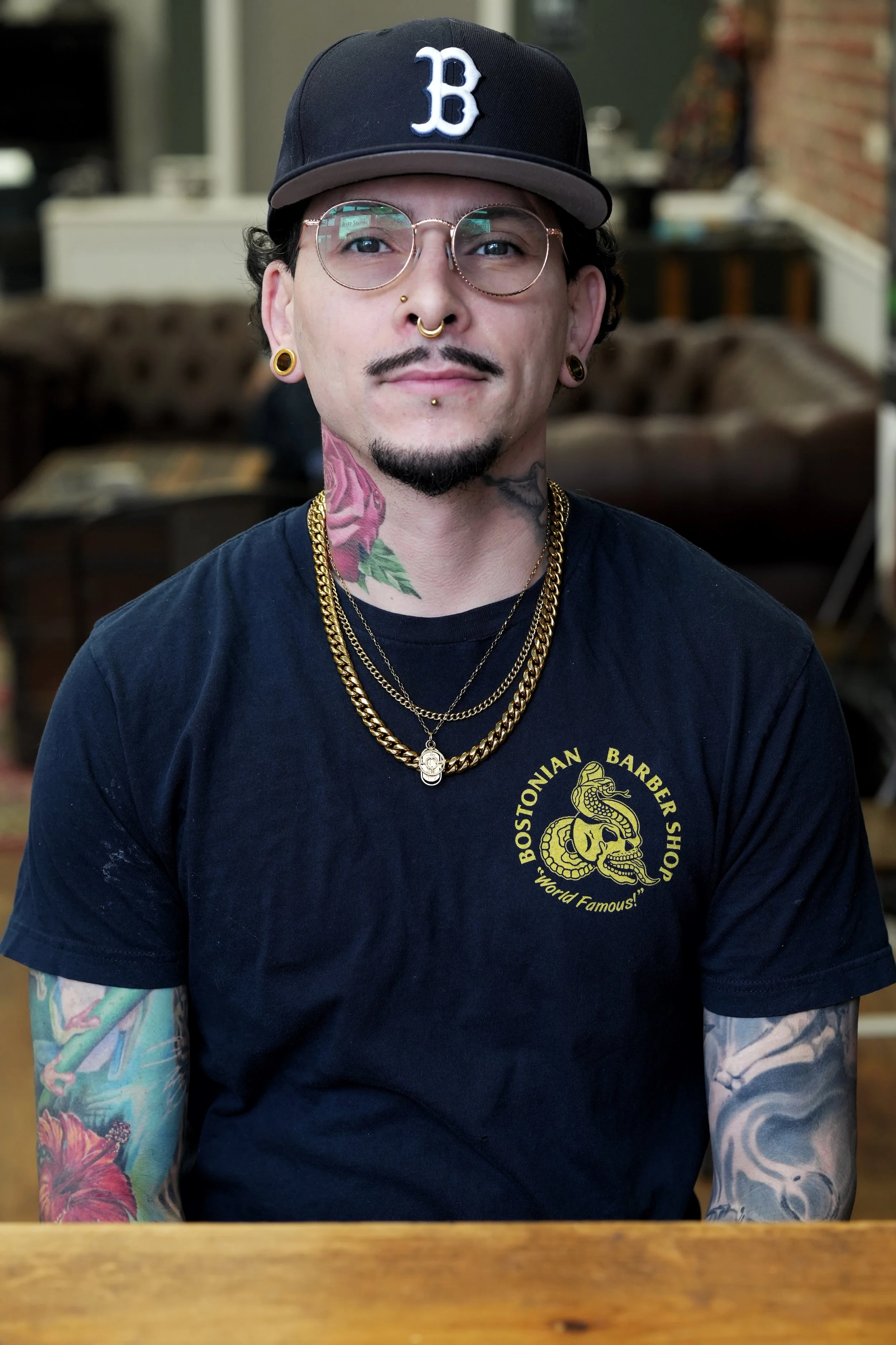 barber with mustache, glasses tattoos, piercings and chains