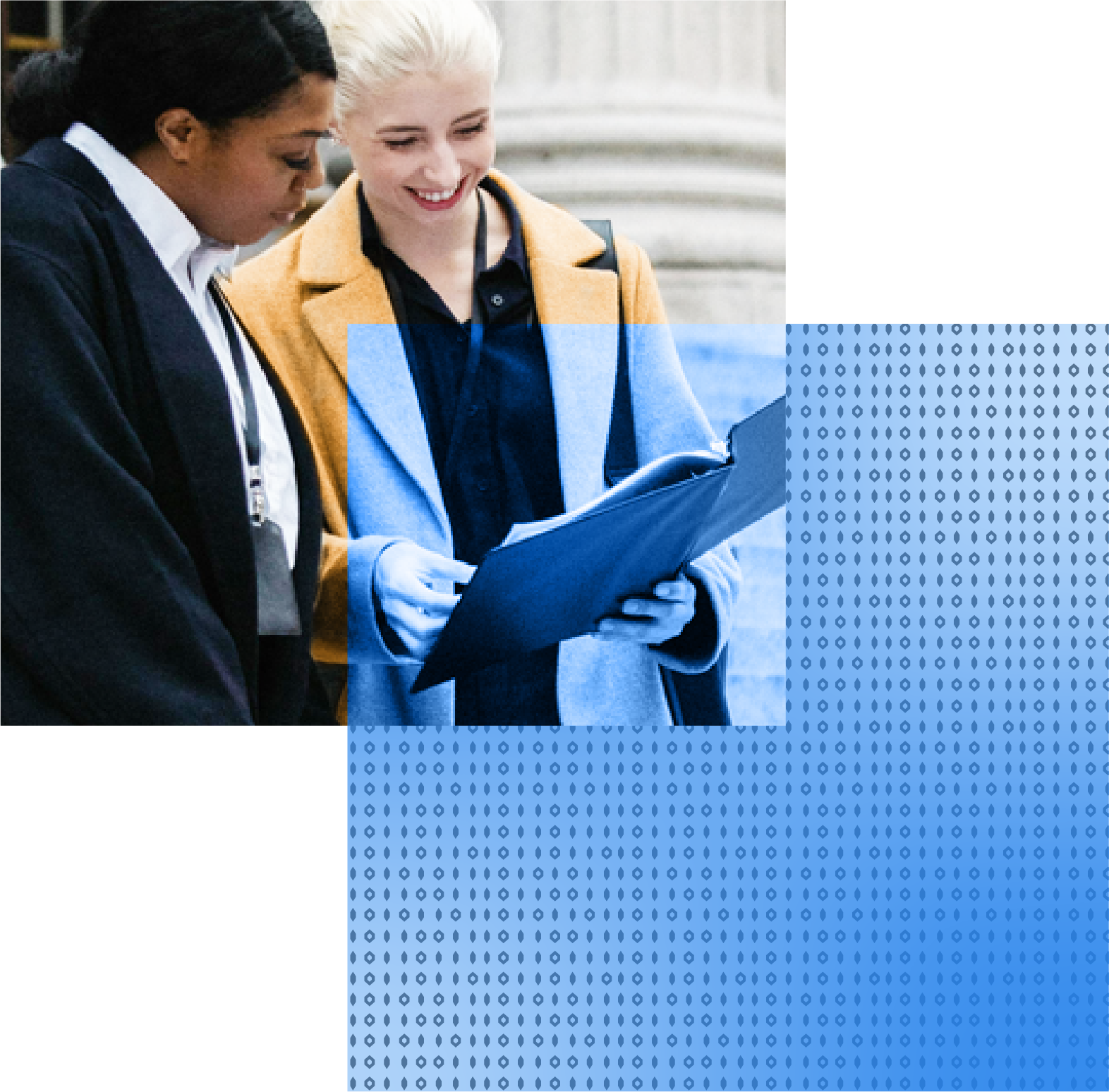 Two women in business attire looking at a document, standing outside a building with steps.
