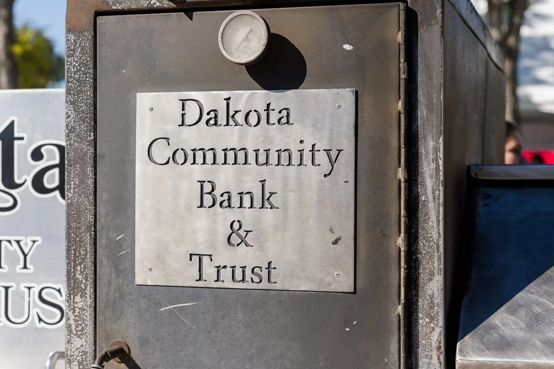 Metal bank and trust box with a sign that reads 'Dakota Community Bank & Trust'