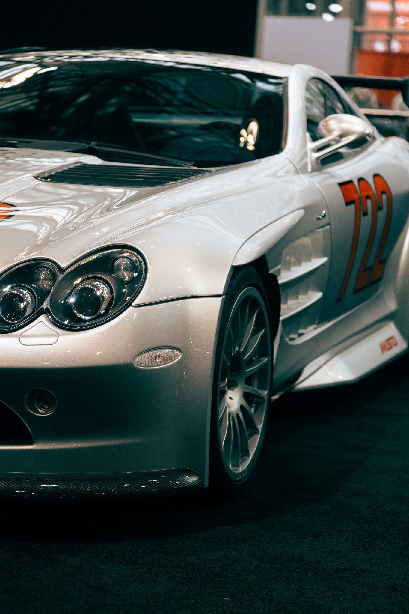A silver race car with the number 722 on the side, parked indoors.
