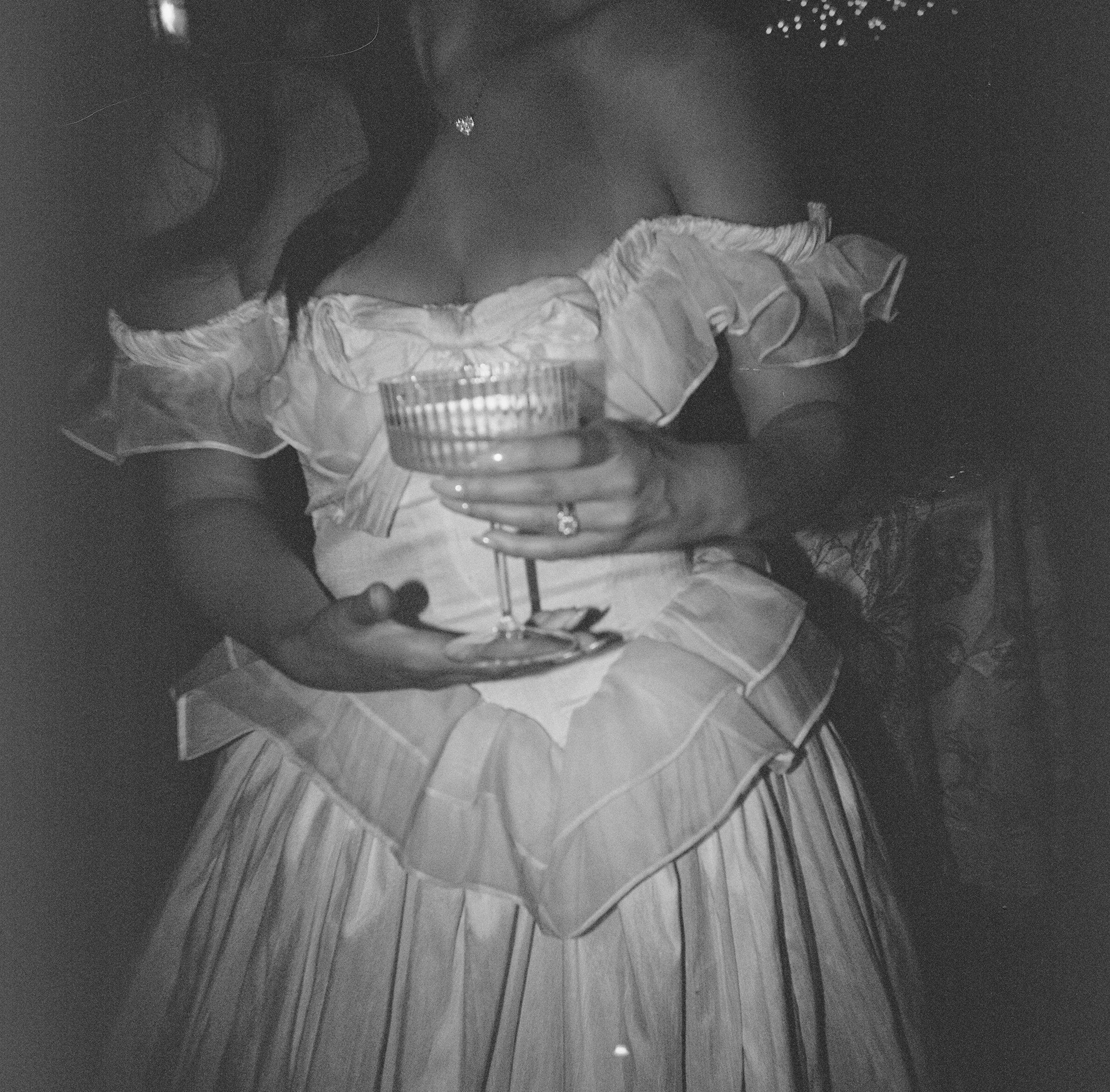 Bride seated with a glass of wine at Europa Village in Temecula Wine Country, California, during a romantic luxury wedding, captured in artistic black and white.
