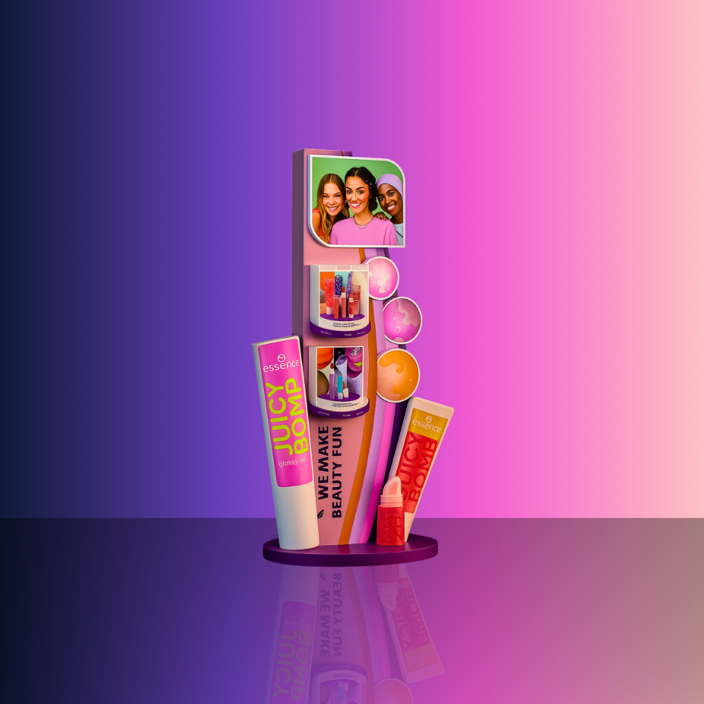 Display of colorful Essence beauty products, including lip gloss and balm, with a photo of three smiling women on top, set against a pink and purple gradient background.