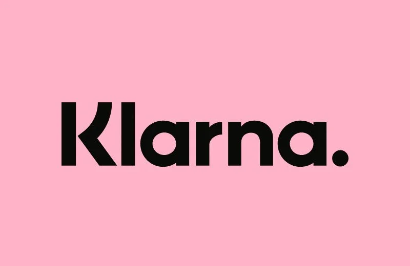 The word 'Klarna' in bold black letters on a pink background.