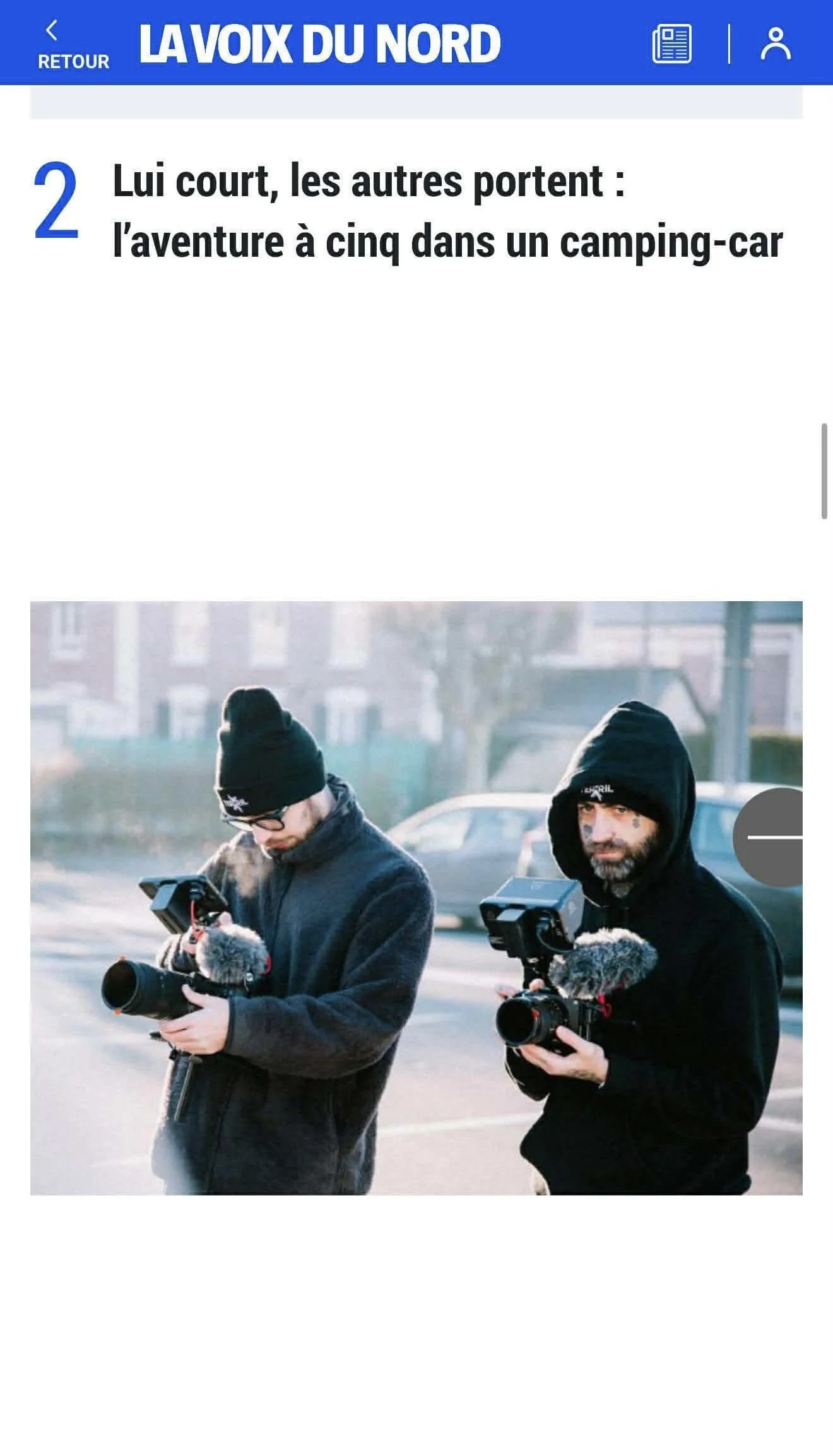 Deux hommes vêtus de vêtements d'hiver, portant des bonnets, tenant des caméras de vidéo et de photographie lors d'une prise de vue en extérieur.