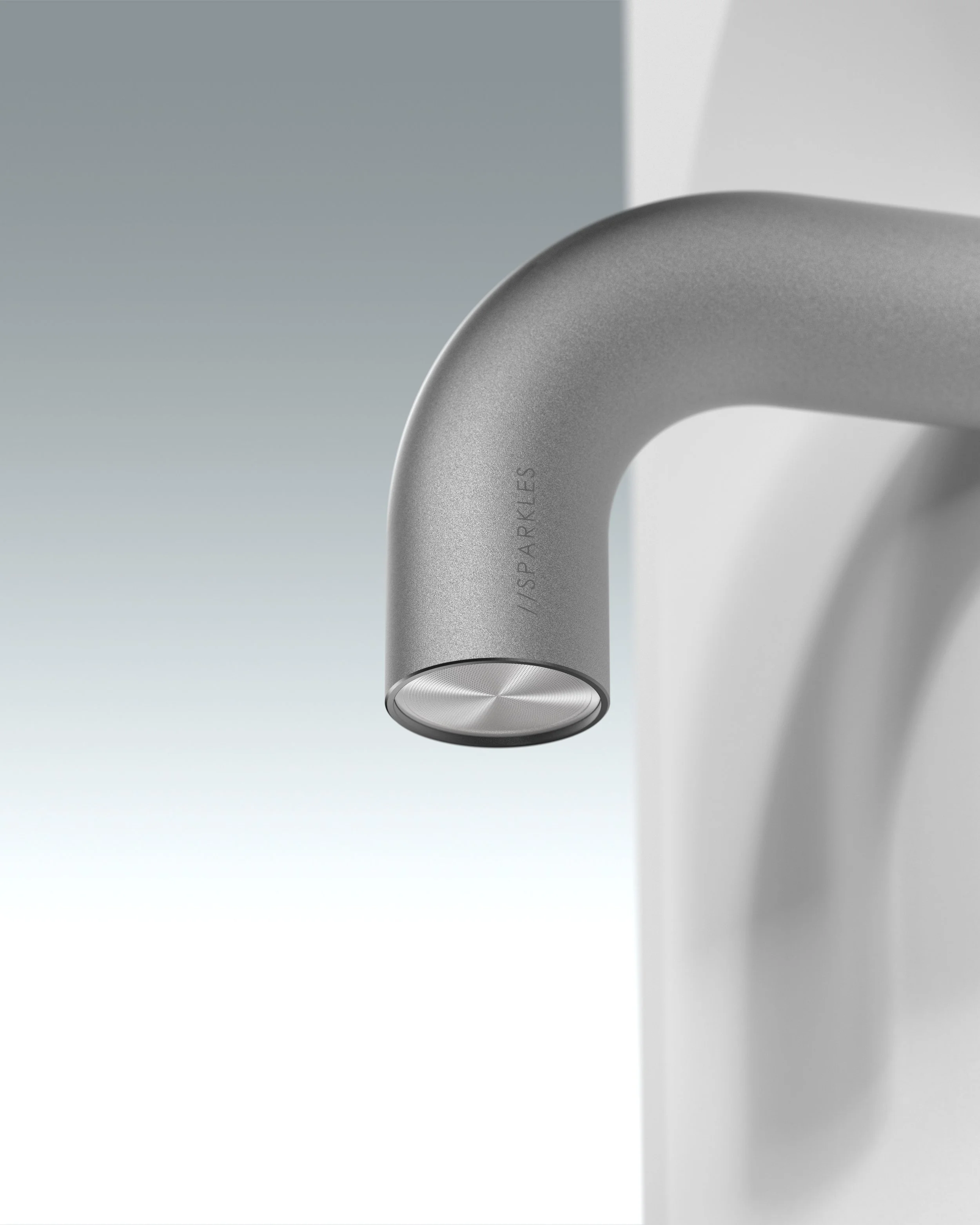 Close-up of a modern, metallic faucet mounted on a white wall.