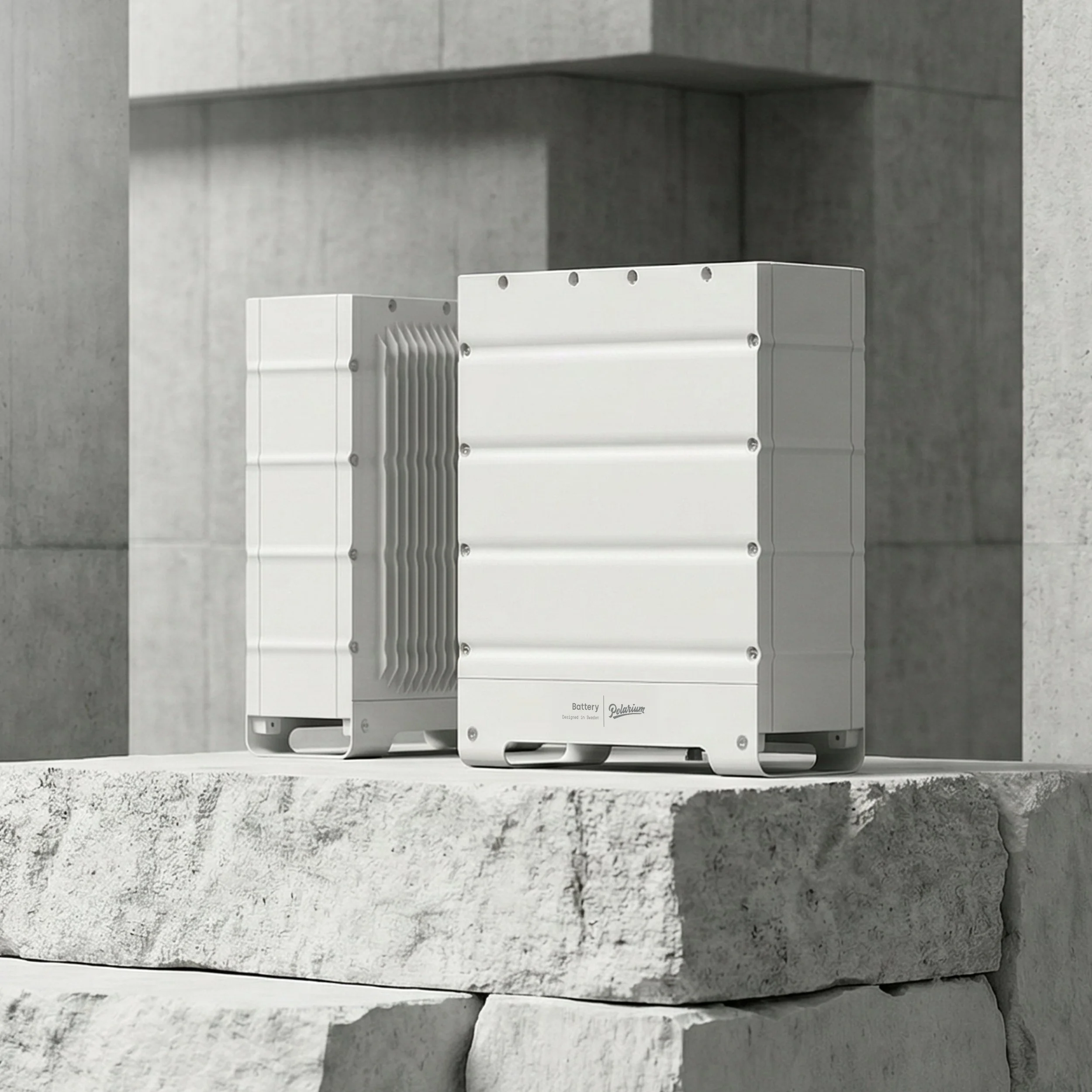 Two large white battery units with fins for cooling placed on a concrete surface against a concrete wall.