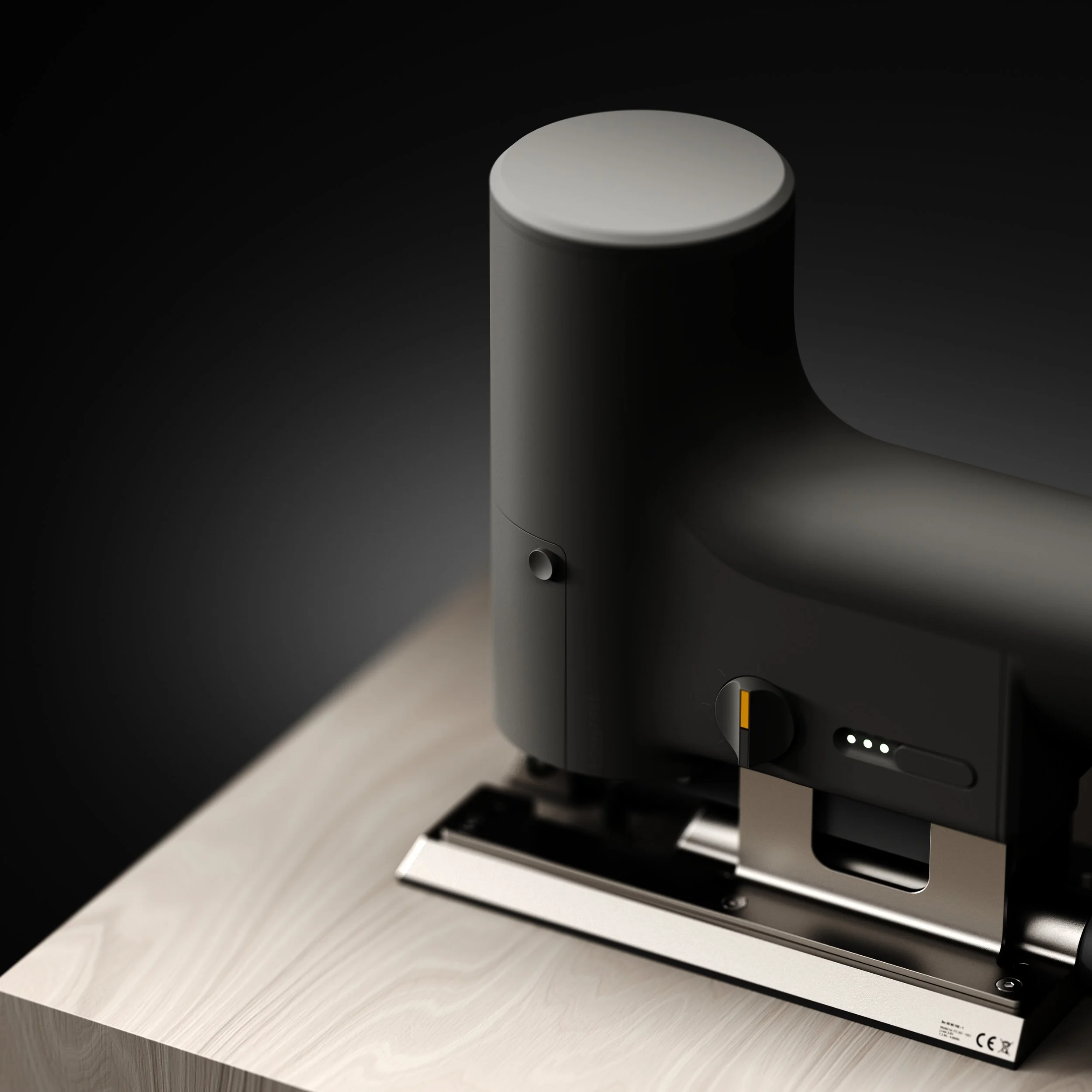 A close-up of a high-tech, black electric staple gun on a light wooden surface, with a dark background.